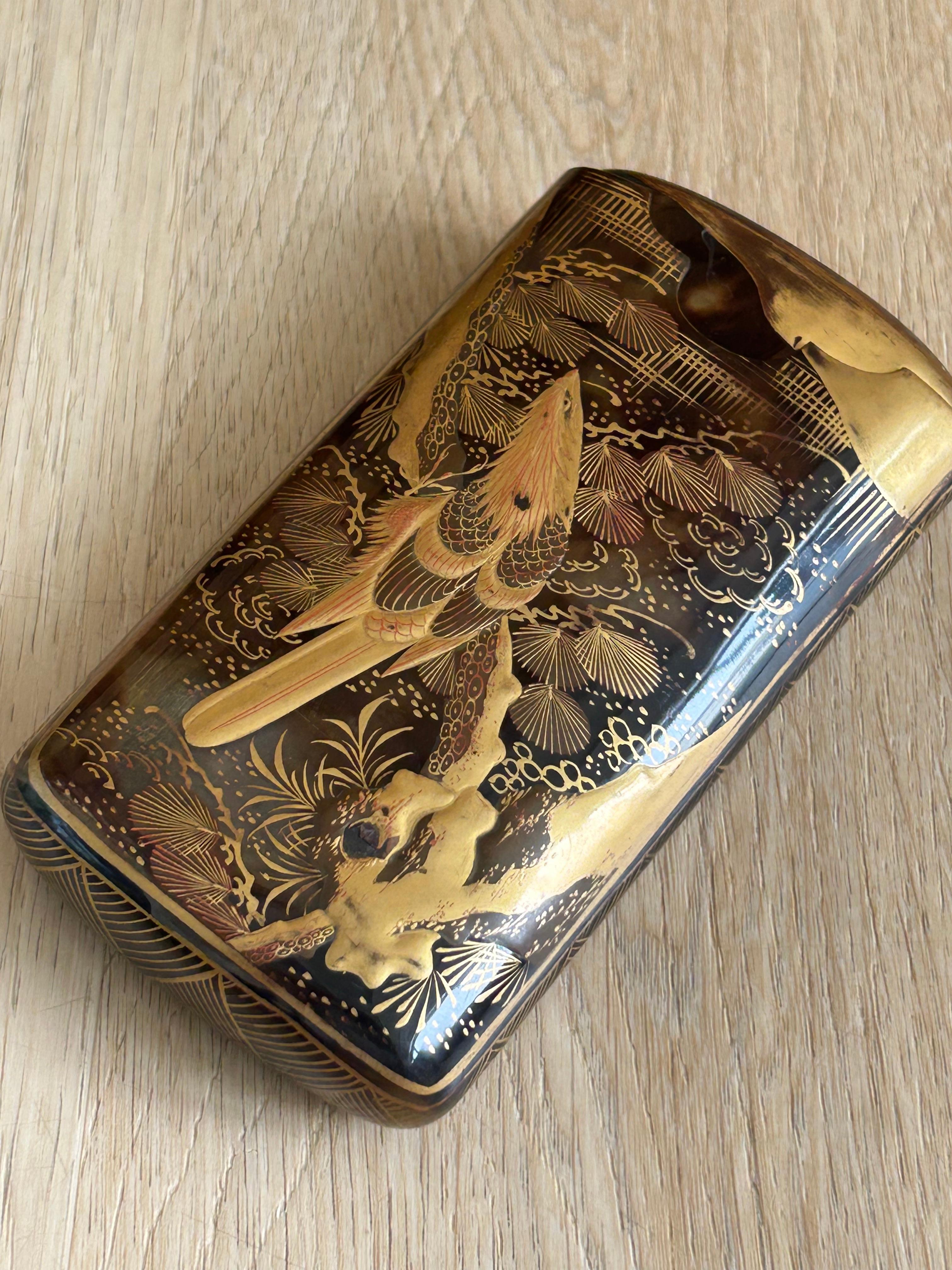 Tortoiseshell cigar holder, with Japanese inspired decoration. Painted and inlaid with some losses. On one side it represent a bird on a branch in the middle of nature and on the other side coins and gold bars.

The pictures are part of the