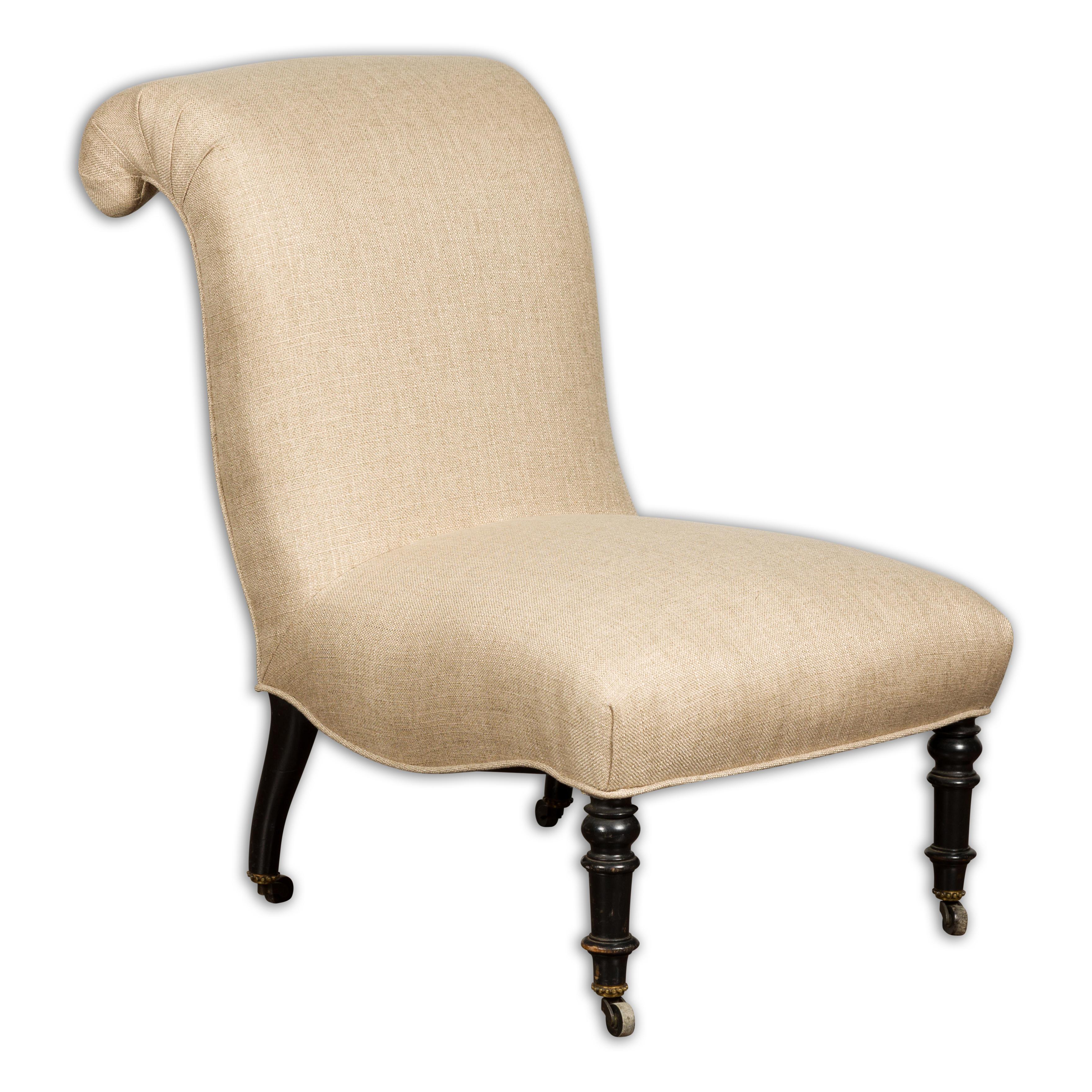 A French Turn of the Century slipper chair circa 1900 with out-scrolling back, turned legs in the front and casters, with newly done linen reupholstery. This French Turn of the Century slipper chair, circa 1900, is an epitome of refined elegance,
