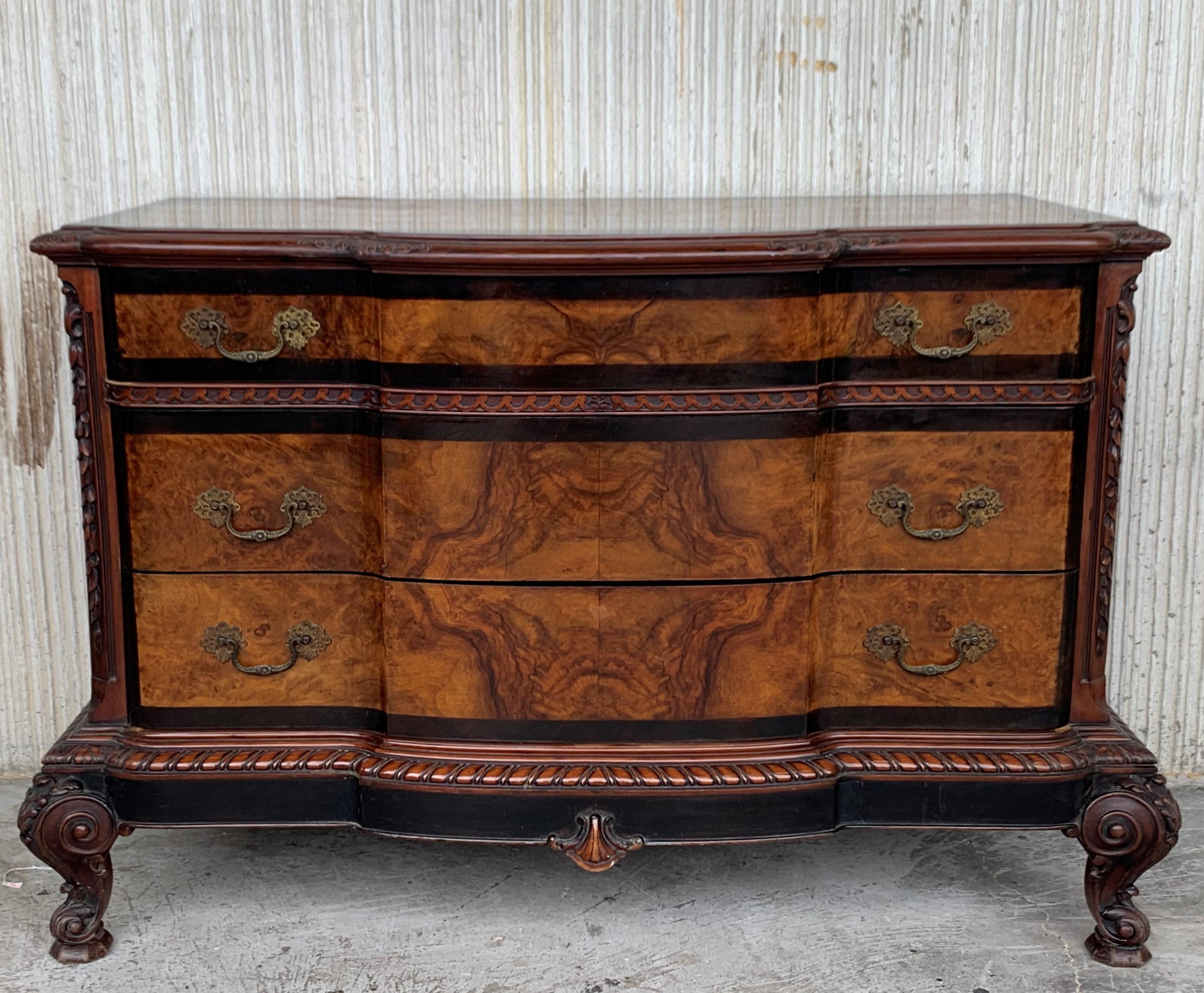 A elegant serpentine Venetian 1900s Baroque commode chest of drawers in ebonized hand carved walnut and walnut veneered, drawers and top with molded edges, raised on a plinth base resting on bracket feet.
Bronze burnished handles
Restored and