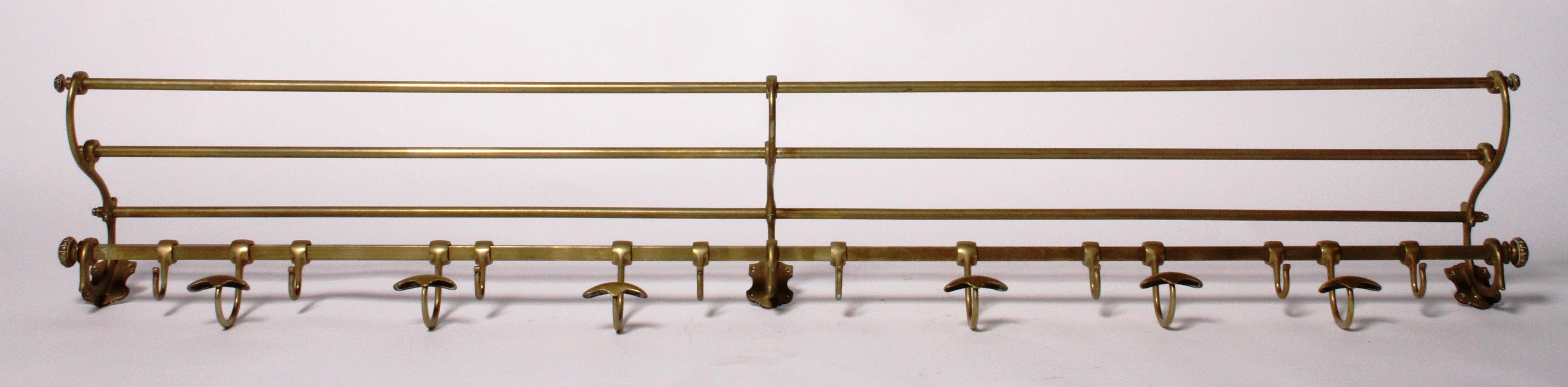 This beautiful piece originated from the early 1900s in France and was once used as a coat a luggage rack on a train. This brass metal vintage rack is wall mounted and has adjustable coat hooks that slide across the bottom rod.