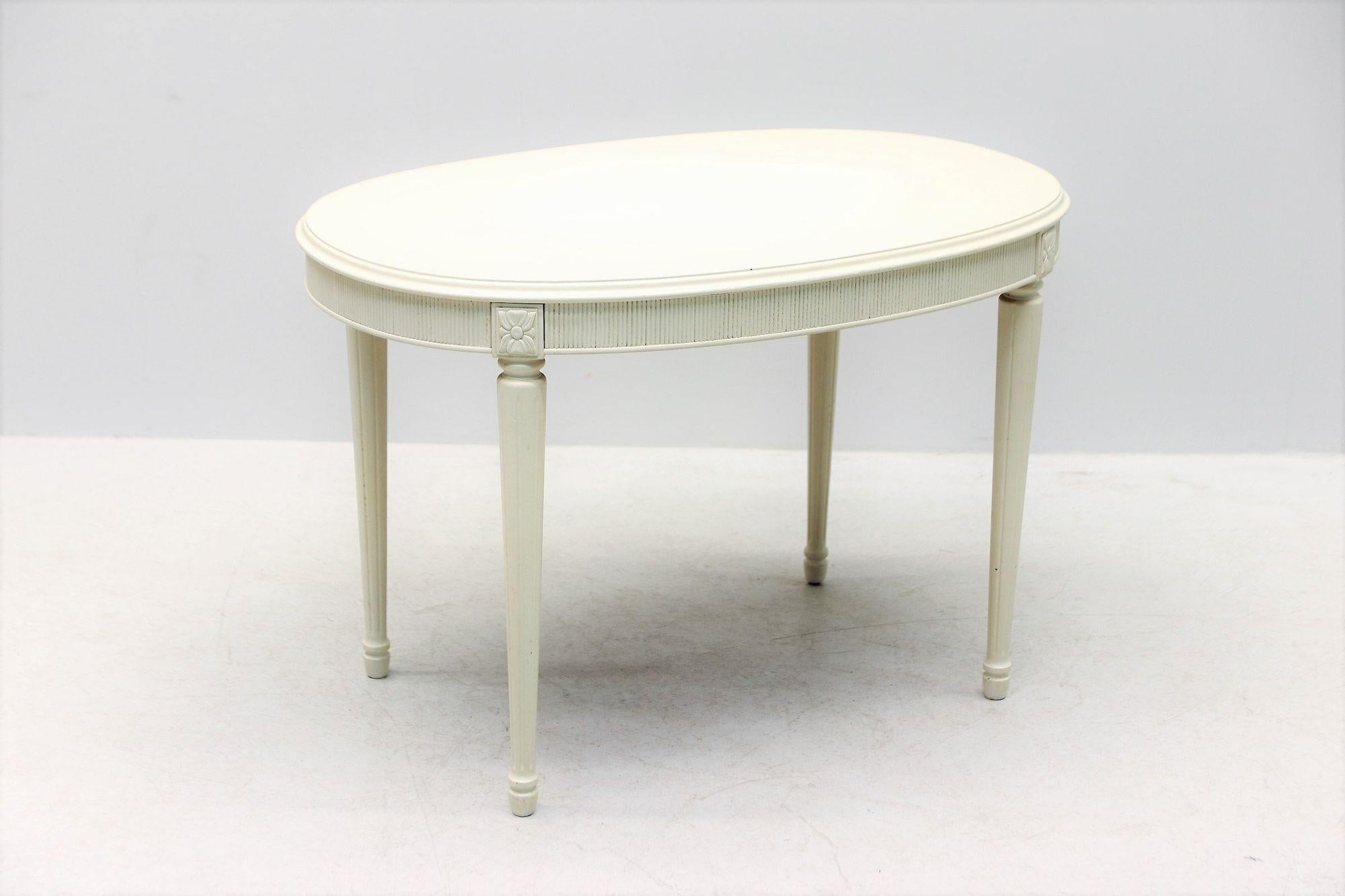1900s white-painted Swedish Gustavian-style salon table. Simple and stylish, this Gustavian-style salon table from the early 1900s is painted a creamy Swedish white and would make an elegant addition to any room. It features a fluted apron and legs