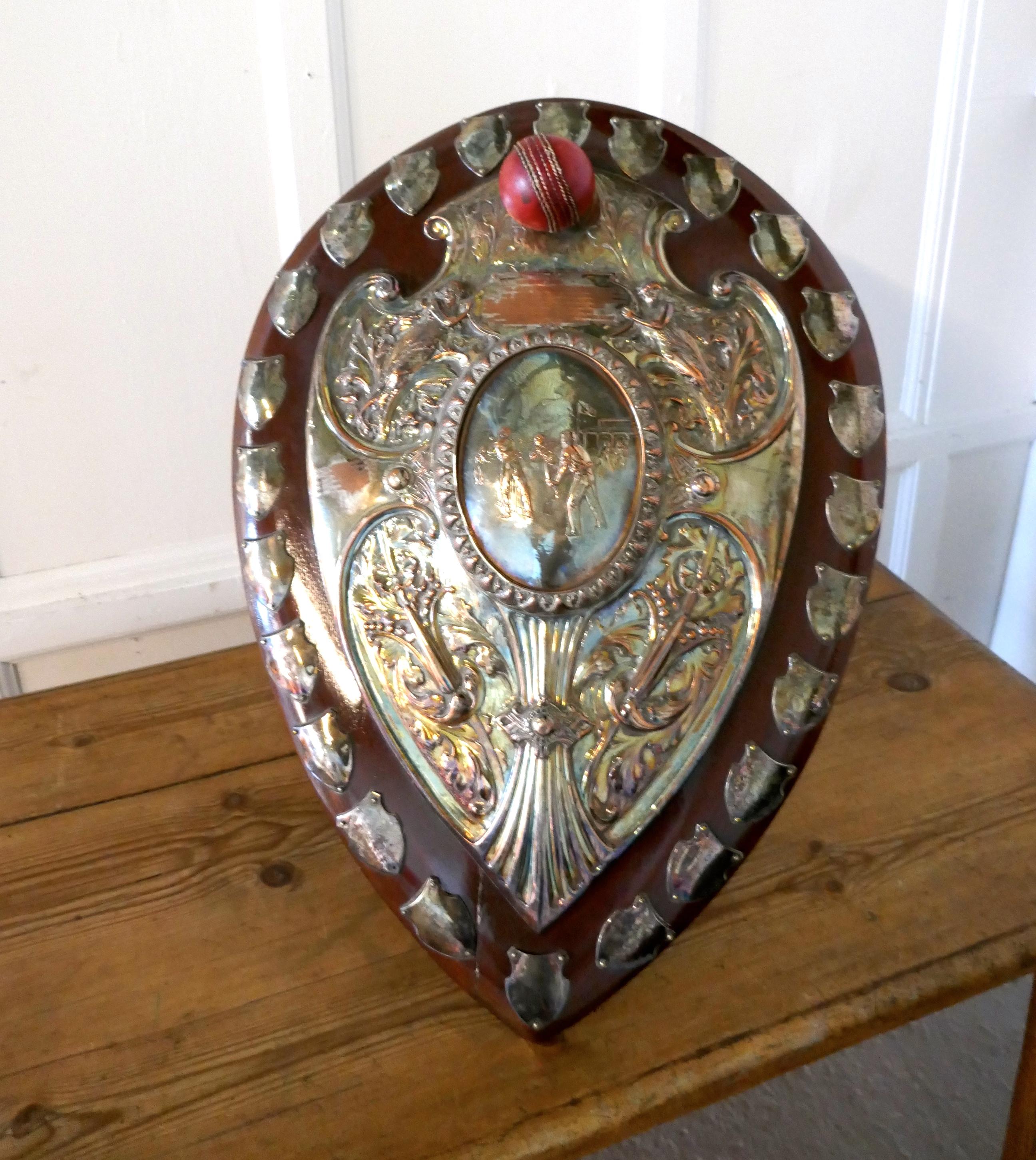 1901 Art Nouveau Sheffield Plate Cricket Trophy Shield, by Walker Hall and Sons

This is a fantastic piece, a work of art, the Oak shield has an embossed Sheffield Silver plate, in the centre of this a scene from a cricket match and around this Art