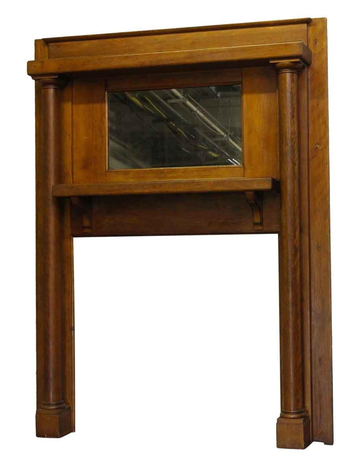 This is a simple turn of the 20th century birch wood mantel, done in a transitional style between Victorian and Arts & Crafts. This mantel is dated 1901 and has all original details handwritten on the back label. It has an antique mirror and full