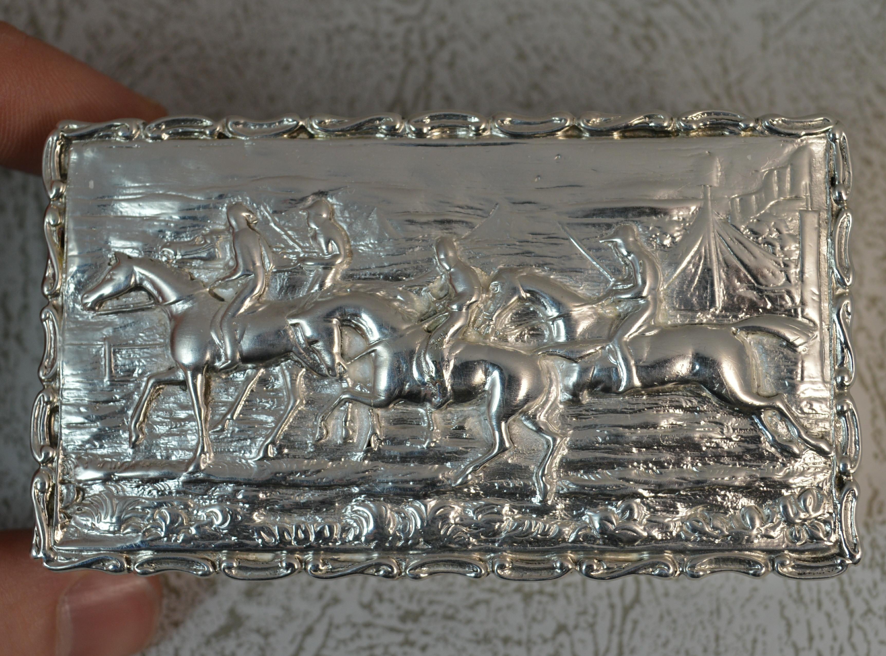 A beautiful solid silver box.
Stylish shaped piece of rectangular shape.
Scenic hunting design to lid. Pattern to edges. Plain sides.

Hallmarks ; full hallmarks to base
Weight ; 92 grams 
Size ; 8.4cm x 4.6cm x 2.5cm approx
Condition ; Good for