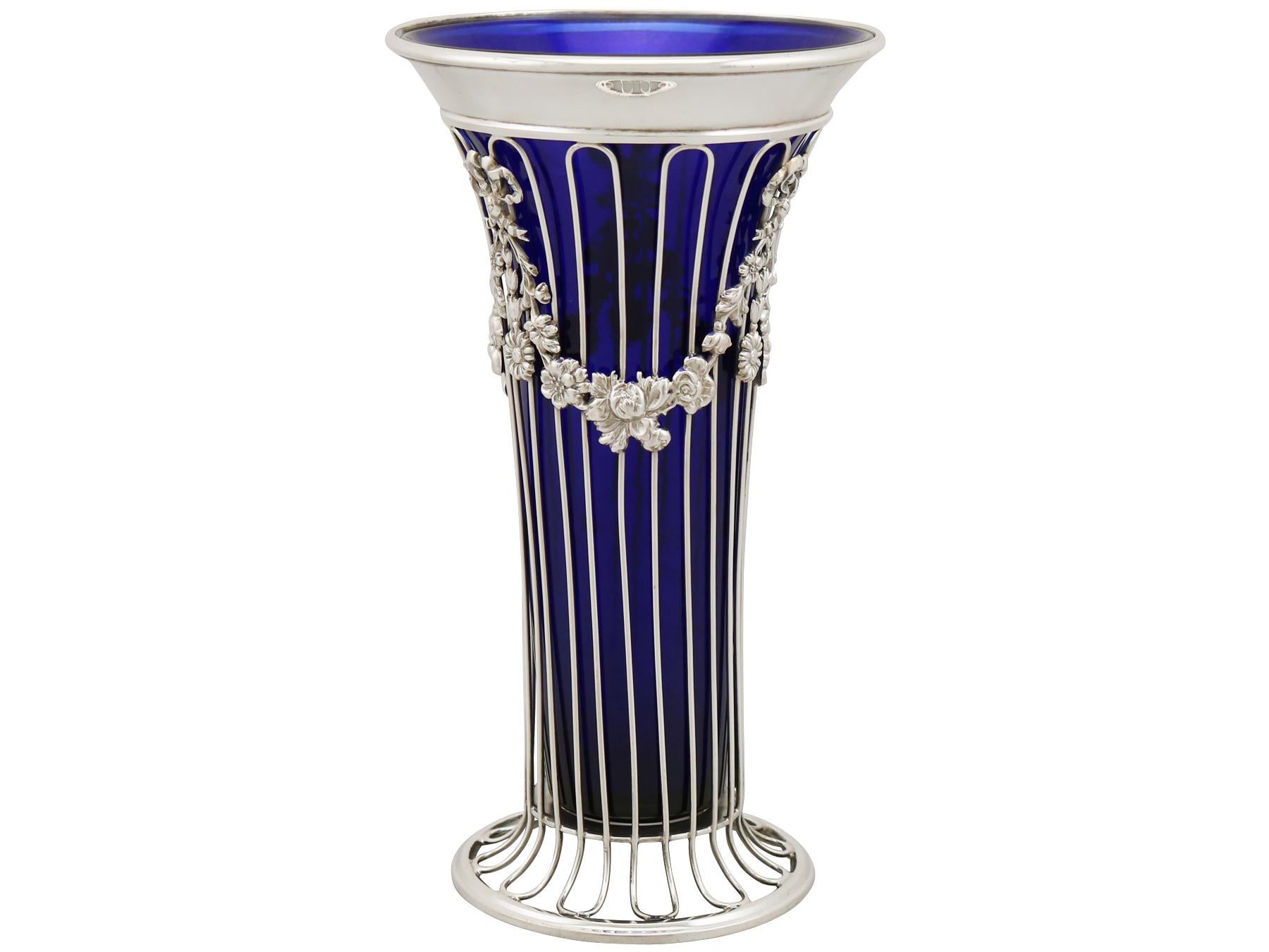 An exceptional, fine and impressive antique Edwardian English sterling silver and glass vase; an addition to our ornamental silverware collection.

This exceptional antique sterling silver vase has a tapering cylindrical form to a swept circular