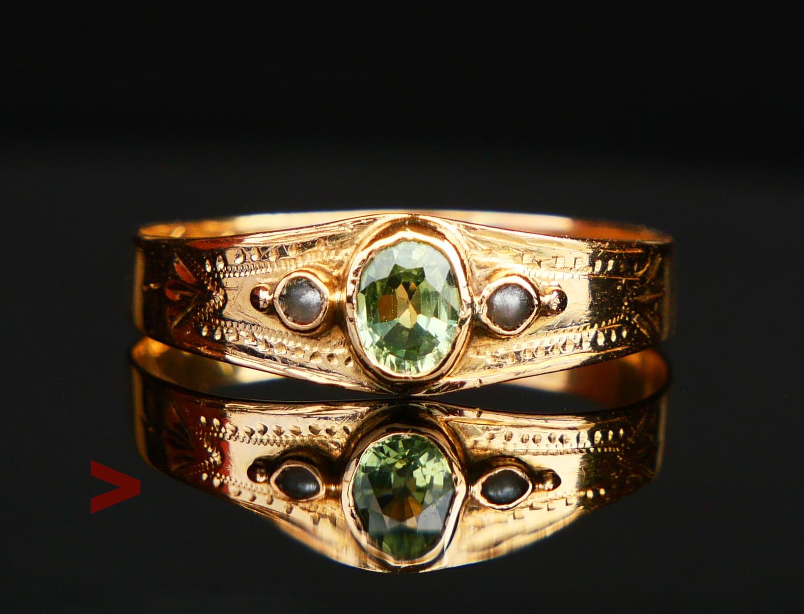 Ein Ring mit handgravierten Ornamenten und einer natürlichen Lünette  Saphir von grüner Farbe oval geschliffen 5 mm x 4 mm  x 2,3 mm tief / ca. 0,5 ct. akzentuiert mit zwei natürlichen schwedischen Flussperlen Ø 1,5 mm. Der Saphirstein weist eine