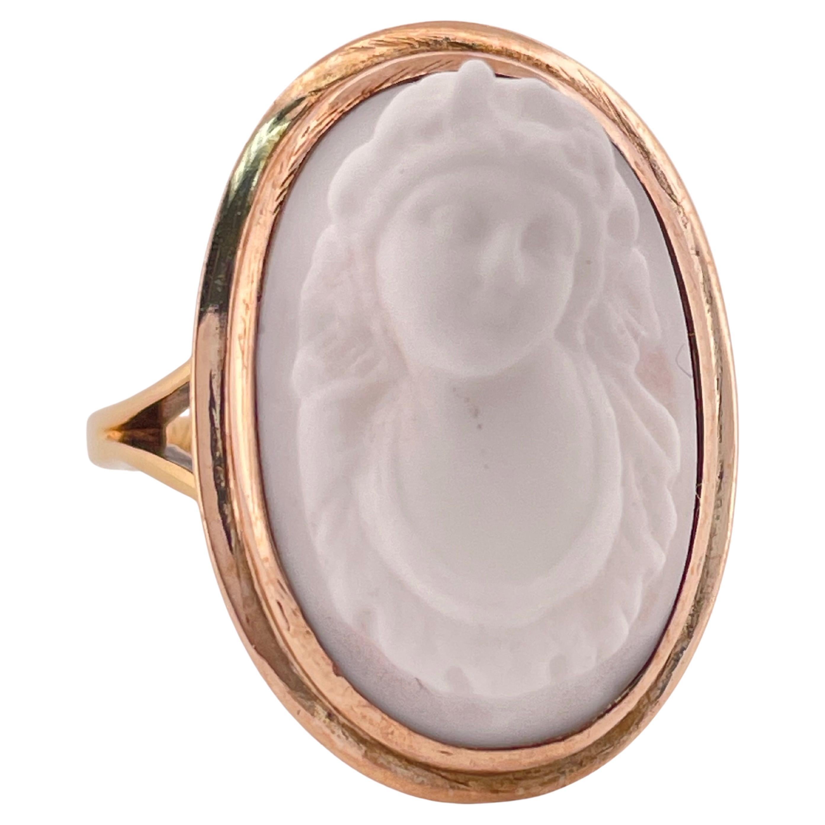 Dieser exquisite antike Ring aus dem Jahr 1905 ist ein bemerkenswertes Zeugnis der Kunstfertigkeit des frühen 20. Das aus massivem 14-karätigem Gold gefertigte Schmuckstück zeigt ein fein geschnitztes weißes Kamee-Mittelstück, das in eine glatte