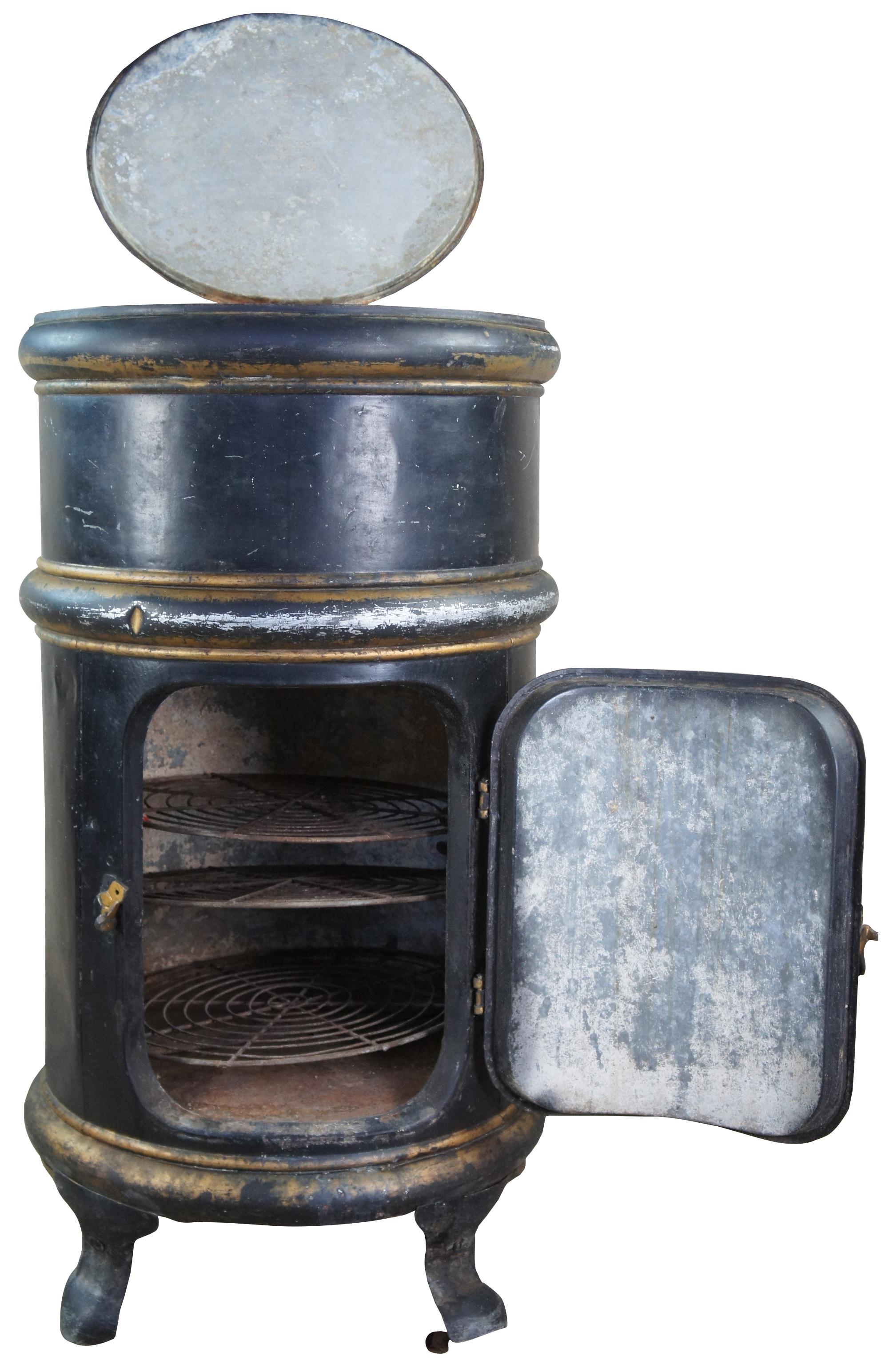 Antique pressed steel ice box refrigerator, with industrial design, hinged lid and door, with three round iron revolving shelves, supported by four shaped legs. Made in Jackson Michigan.
  