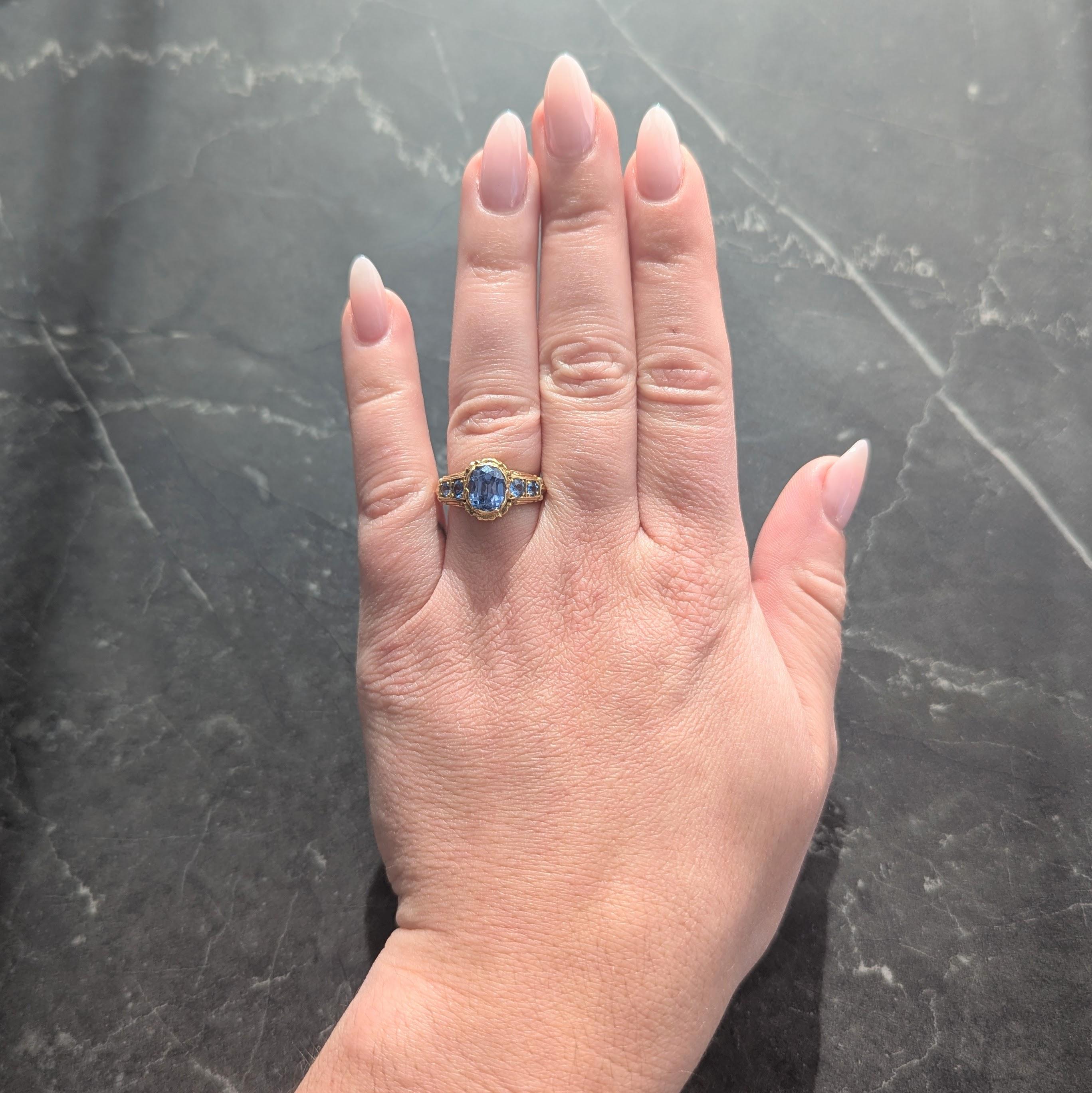 Al centro uno zaffiro taglio cuscino del peso di circa 3,08 carati - trasparente e di colore blu chiaro.
Incastonato in un cesto ornato a motivo floreale con petali che si ripiegano sul castone.
Fiancheggiato da spalle traforate in stile cattedrale,