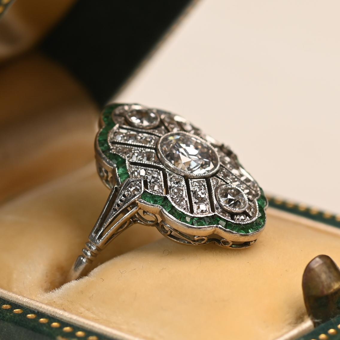 A stunning Edwardian era ring centering a bezel-set old European cut diamond weighing approximately 0.50 carats, with an I color and VS2 clarity. Surrounding the center stone is an elongated filigree design adorned with diamonds and framed by a halo