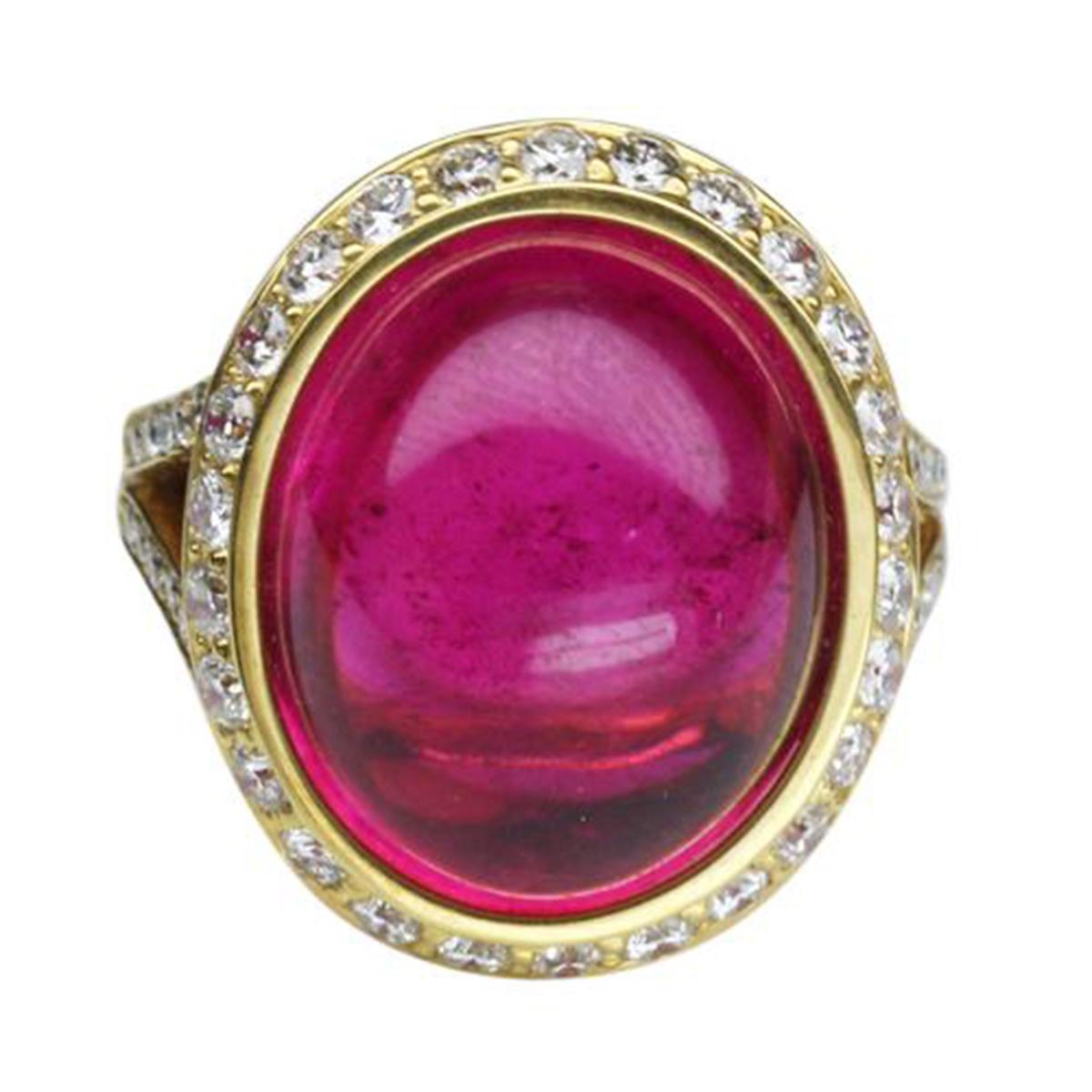Elegant & finely detailed Gold Ring, center set with a securely nestled 19.06 Carat Oval Intense Red Rubelite, measuring approx. 16.5mm x 13.0mm; clarity VS; heat treatment; surrounded by and enhanced on shank with micro-set Brilliant full cut