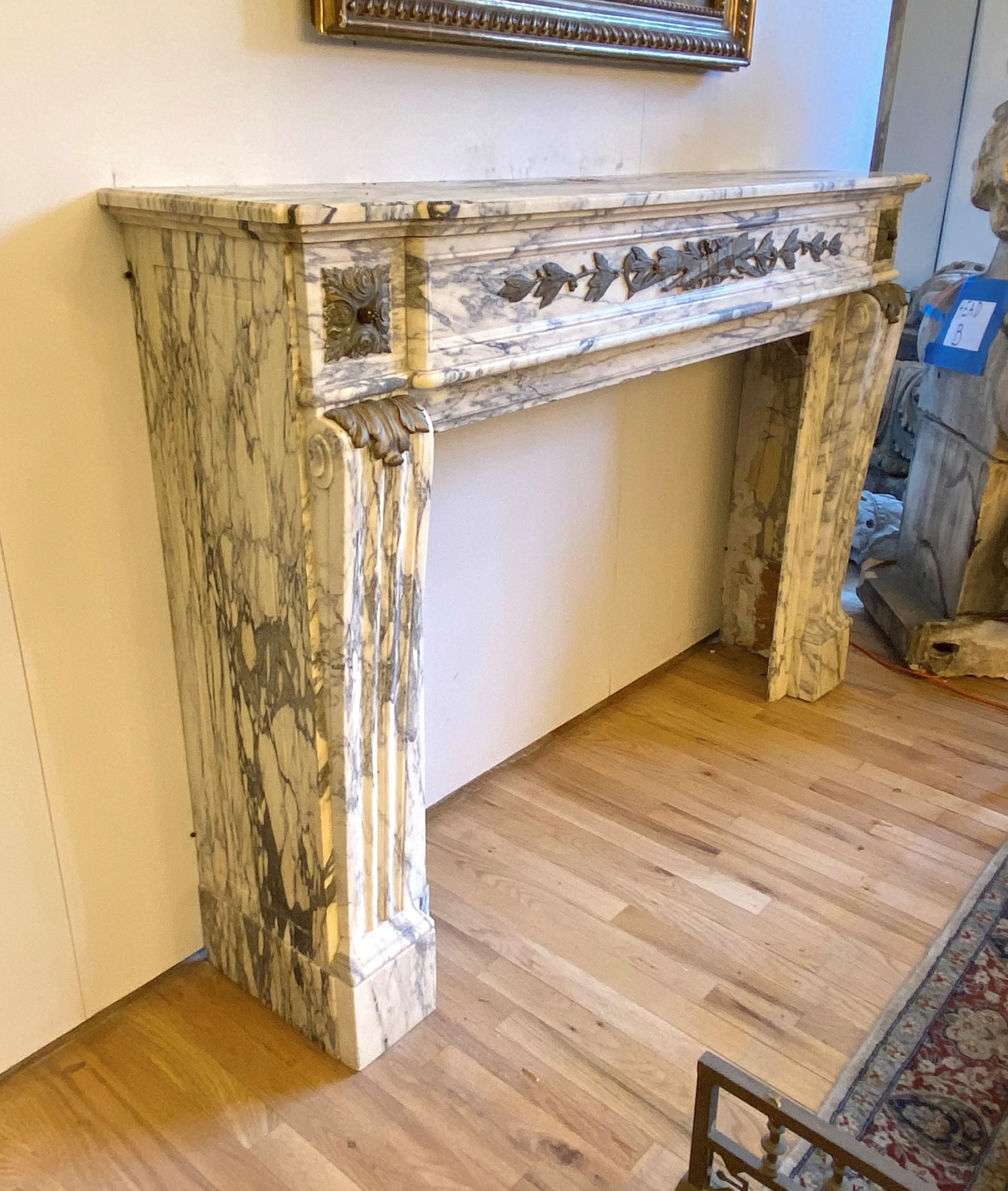 Presented here is an exquisite marble mantel sourced from room 1163 of the renowned Plaza Hotel in New York City. Crafted from premium marble, this remarkable piece showcases intricate hand carvings and is adorned with ornate bronze ormolu details.