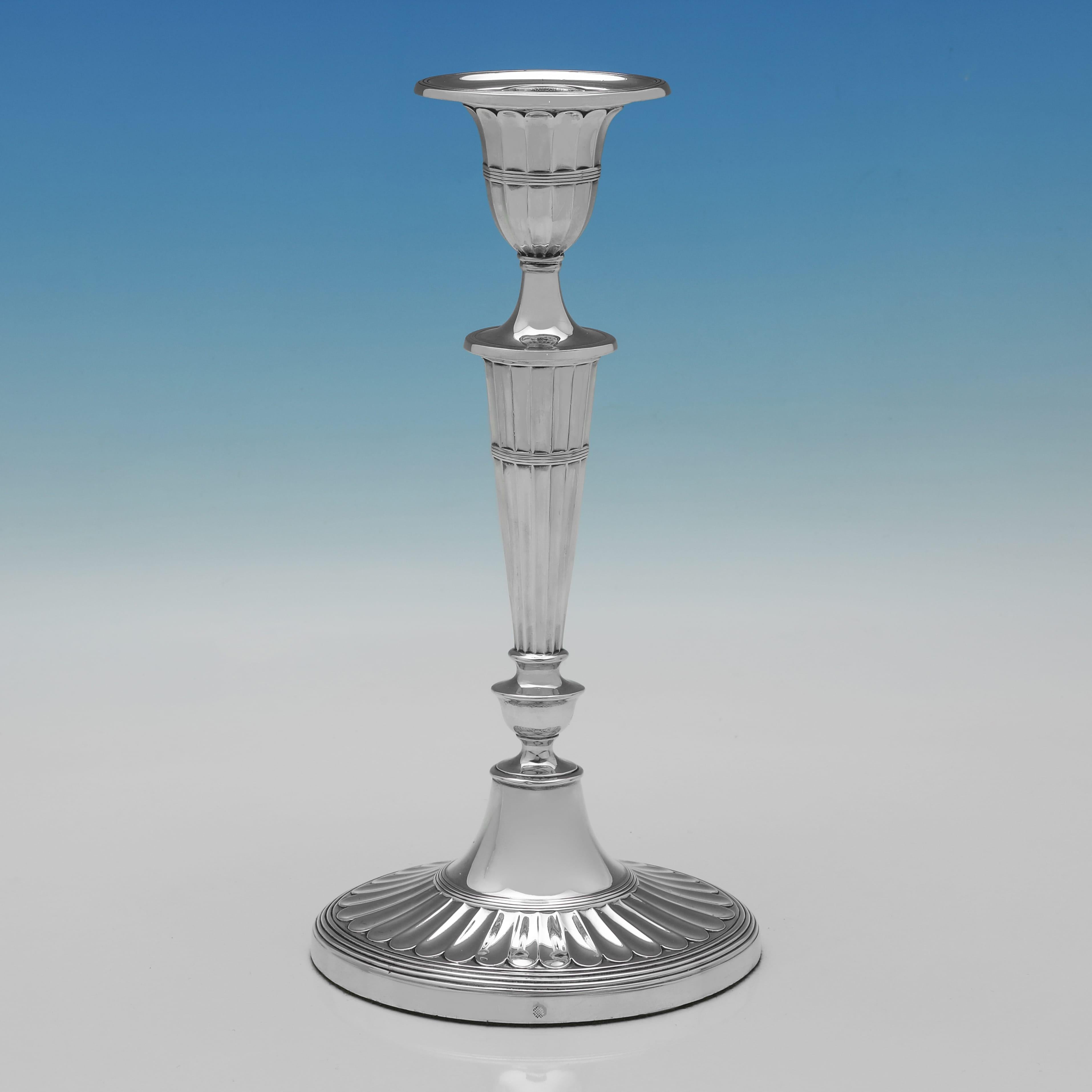 Marchiata a Sheffield nel 1908 da Sharman D. Neill Ltd., questa elegante coppia edoardiana di candelieri in argento sterling ha una forma ovale ed è decorata con steli scanalati e capitelli scanalati, ciascuno dei quali poggia su una base ovale a