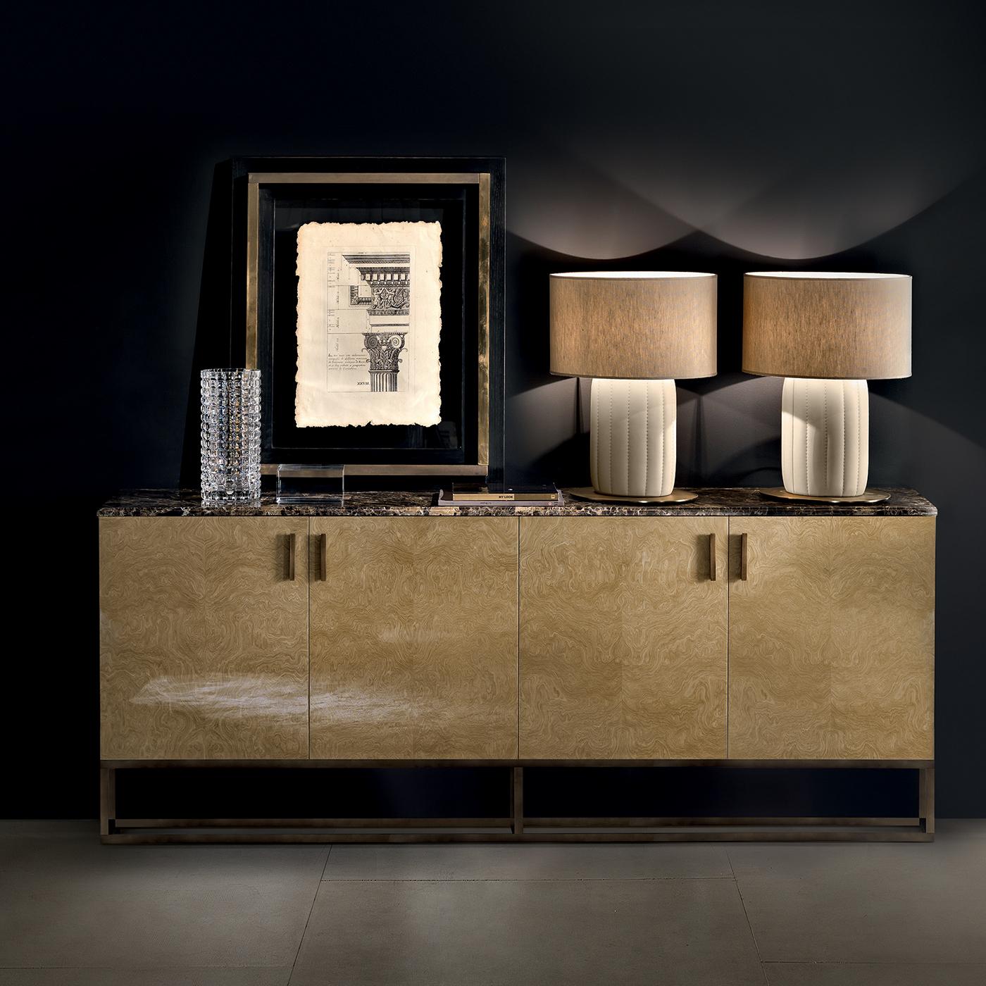 A sideboard of great visual effect with rich and determined personality. Made of plywood with myrtle burl veneer and brushed gloss finish, the two double-door structure is raised on a burnished brass tubular base and is topped with a large