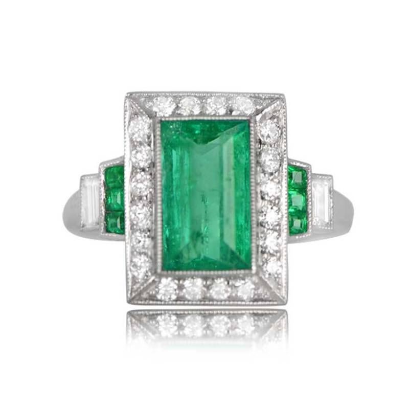 A geometric gemstone ring showcases a 1.90-carat natural step-cut emerald, encircled by an old-cut diamond rectangular halo weighing around 0.68 carats. The shoulders exhibit two steps of natural emeralds and a baguette-cut diamond. Crafted in
