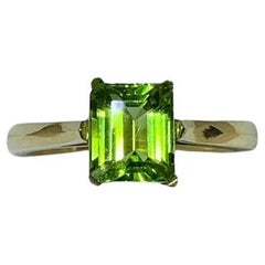 1.90ct Peridot green emerald solitaire engagement ring in 18ct yellow gold.