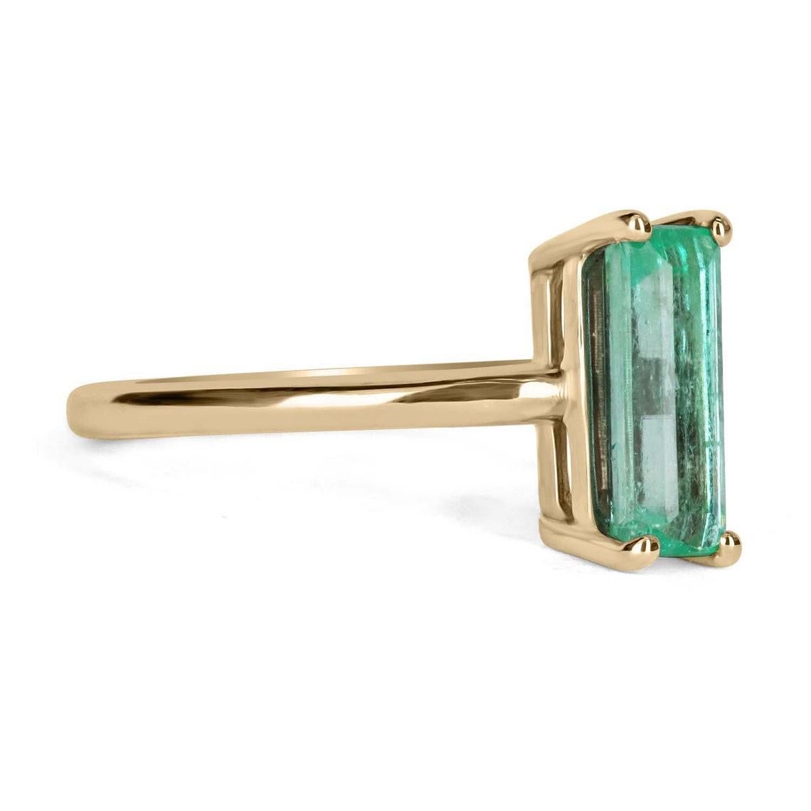 Displayed is a classic RARE Colombian emerald solitaire emerald-cut engagement or right-hand ring in 14K yellow gold. This gorgeous solitaire ring carries a full 1.90-carat emerald in a four-prong setting and the shape is ONE OF A KIND. Fully