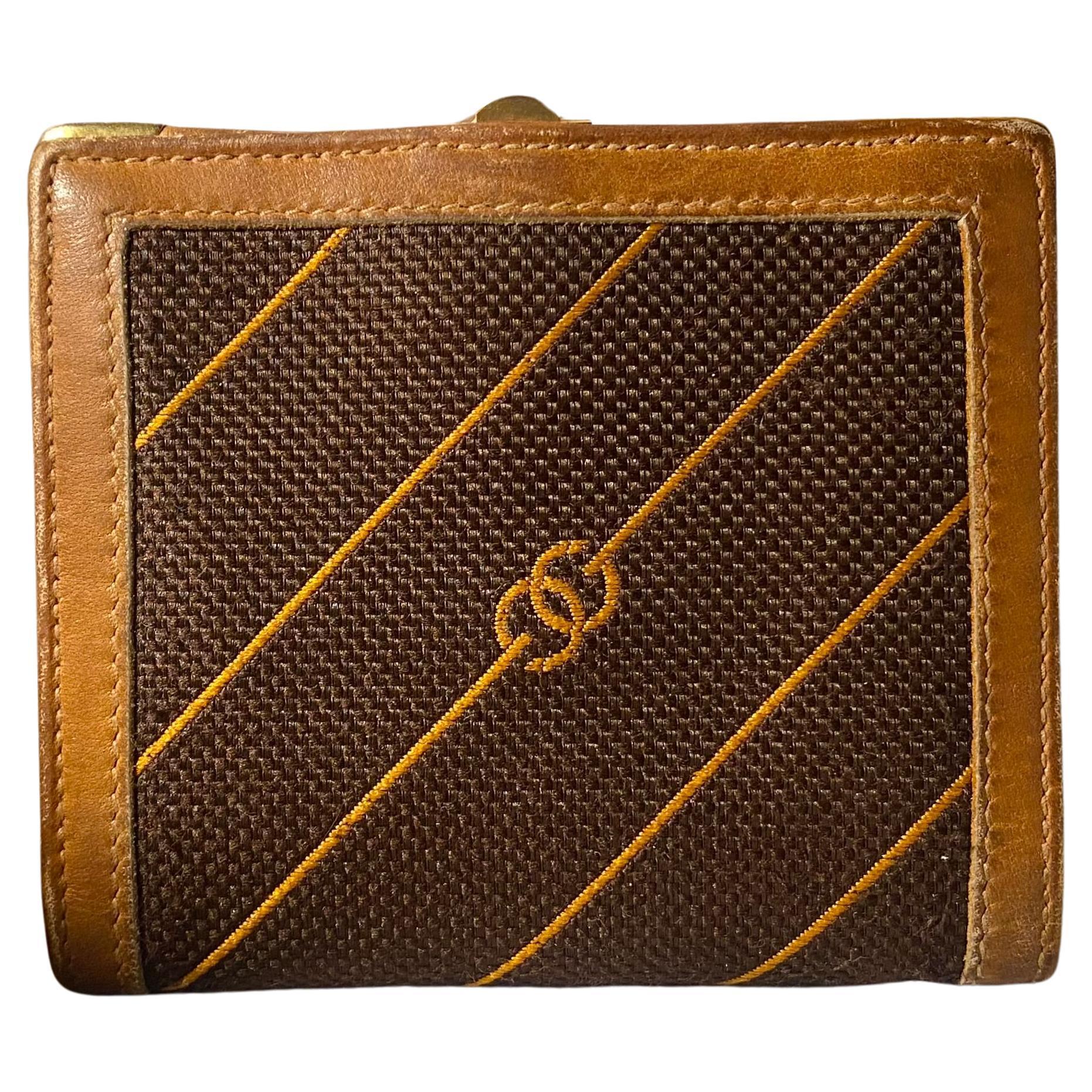 This luxurious Gucci wallet boasts a stunning GG interlocking clutch closure in both light and dark brown canvas. The premium brown leather and gold hardware add a touch of sophistication while the interior features a convenient coin compartment,