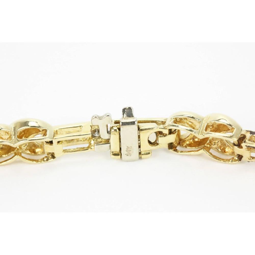 A fancy X-shaped diamond bracelet in 14K yellow gold. This bracelet features a unique golden link embellished by white diamonds. The X's are made in sleek, high-polished gold and resemble the infinity sign. Fifty-six diamonds dance under any light