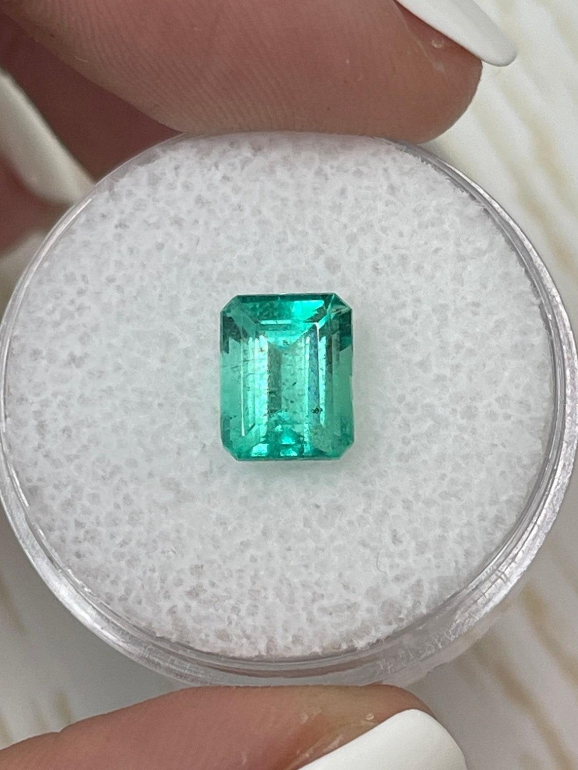 Stone: Emerald
Weight: 1.91-carats
Shape: Emerald Cut
Clarity: Transparent
Luster: Very Good
Color: Light Bluish Green
Measurements: 8.20mm x 6.48mm x 5.07mm
Geographic Origin: Colombia
Treatment: Natural, Oiling

This emerald has a slight chip near