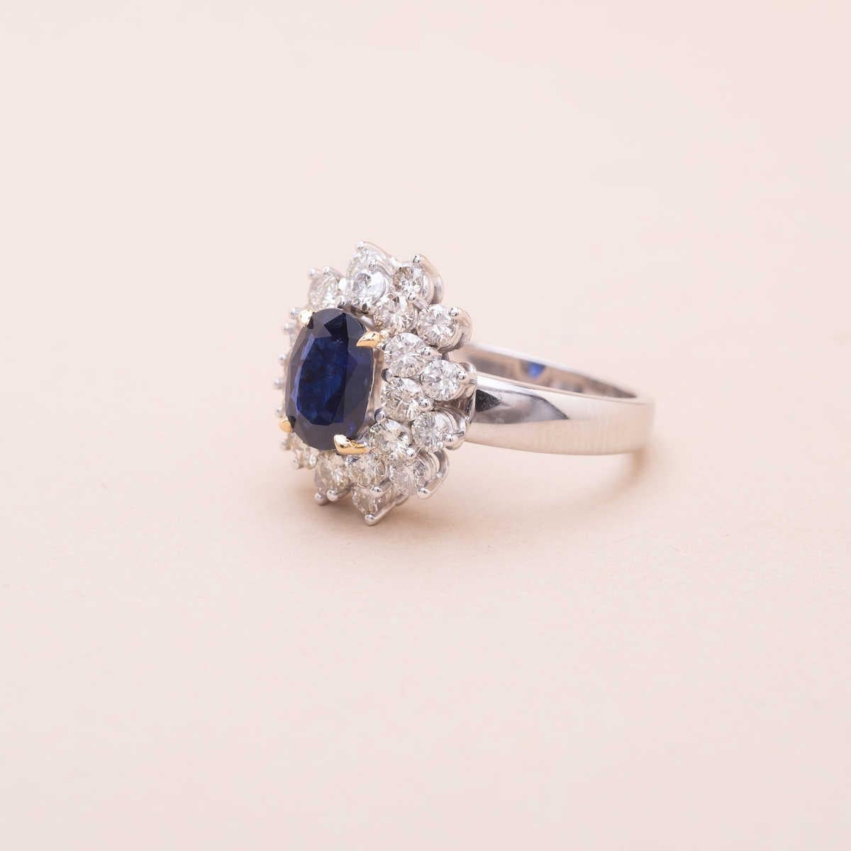 18K white gold 1.91 carat oval-cut sapphire surrounded by a total of 1.6 carat brillant-cut diamonds 
Estimated characteristics : color G to J, purity VS 
Dimensions : 17.20x15.40mm
Ring size (adjustable on demand) : 55 FR 
Gross weight :