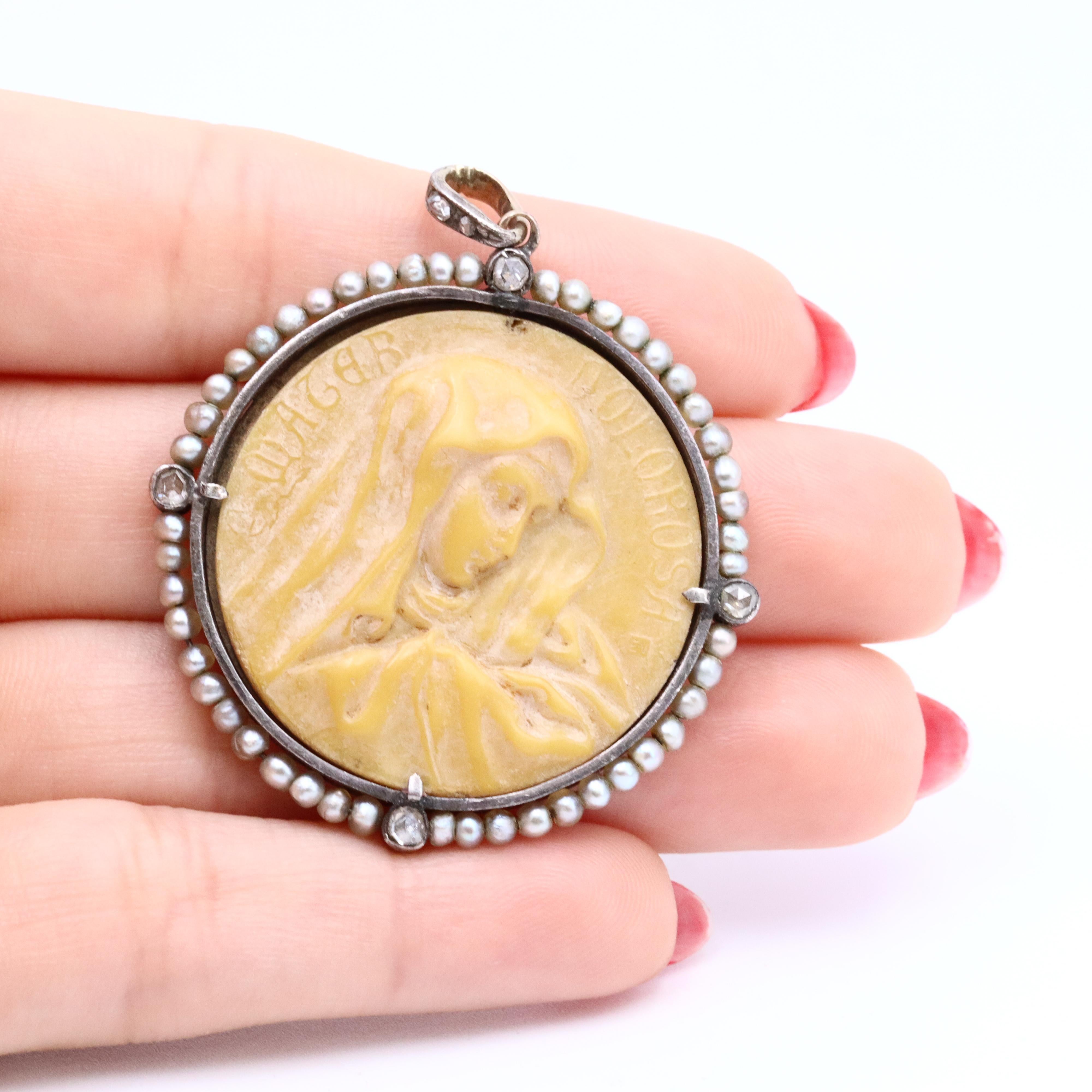 Cet exquis pendentif camée religieux antique de 1910 représente l'élégance pure et l'art de l'époque Elegardienne, méticuleusement réalisé en or rose lustré de 18kt et présentant une image d'une Donna délicatement sculptée dans du corail comme pièce