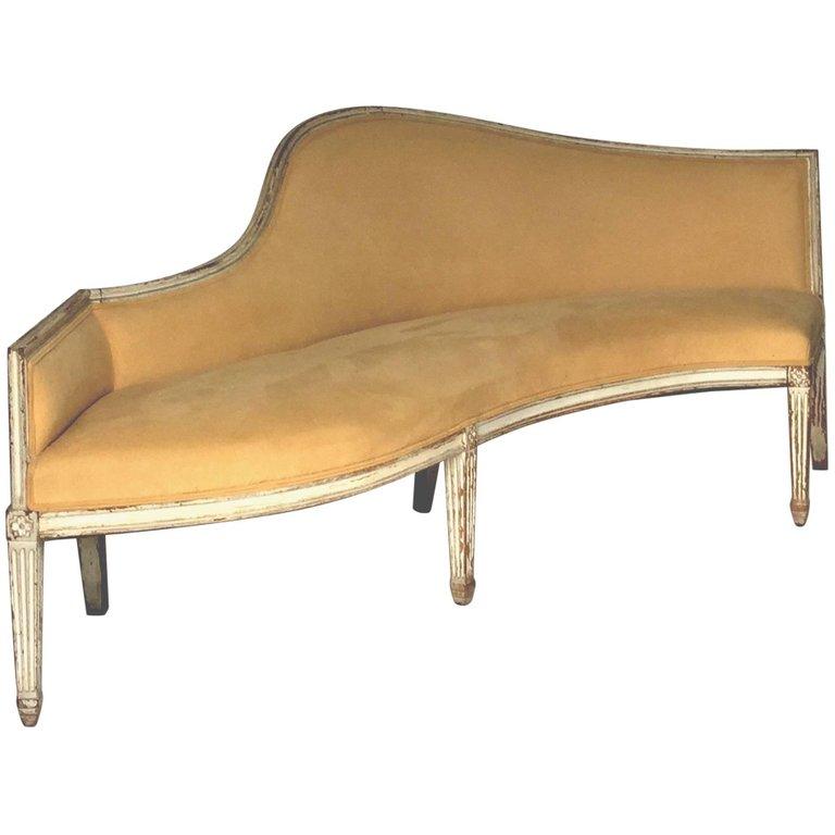 Antique French Louis XVI carved beech settee, painted finish worn with age, unusual sinuous shaped design, reupholstered in buff colored ultra suede with a tiny whole near the back of the seat, square fluted tapering legs with floral rosette details
