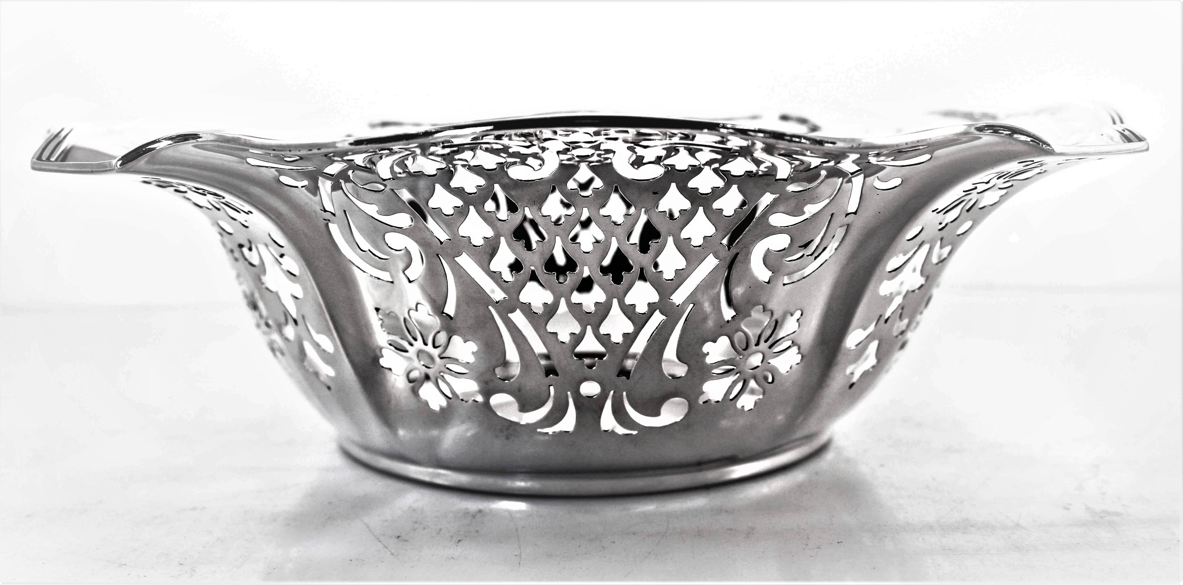 A reticulated bowl with a scalloped edge. On the inside, motifs of pierced work; flowers, fleur de lis and swirls. A truly lovely example of cut-out design from over one hundred years ago.
 