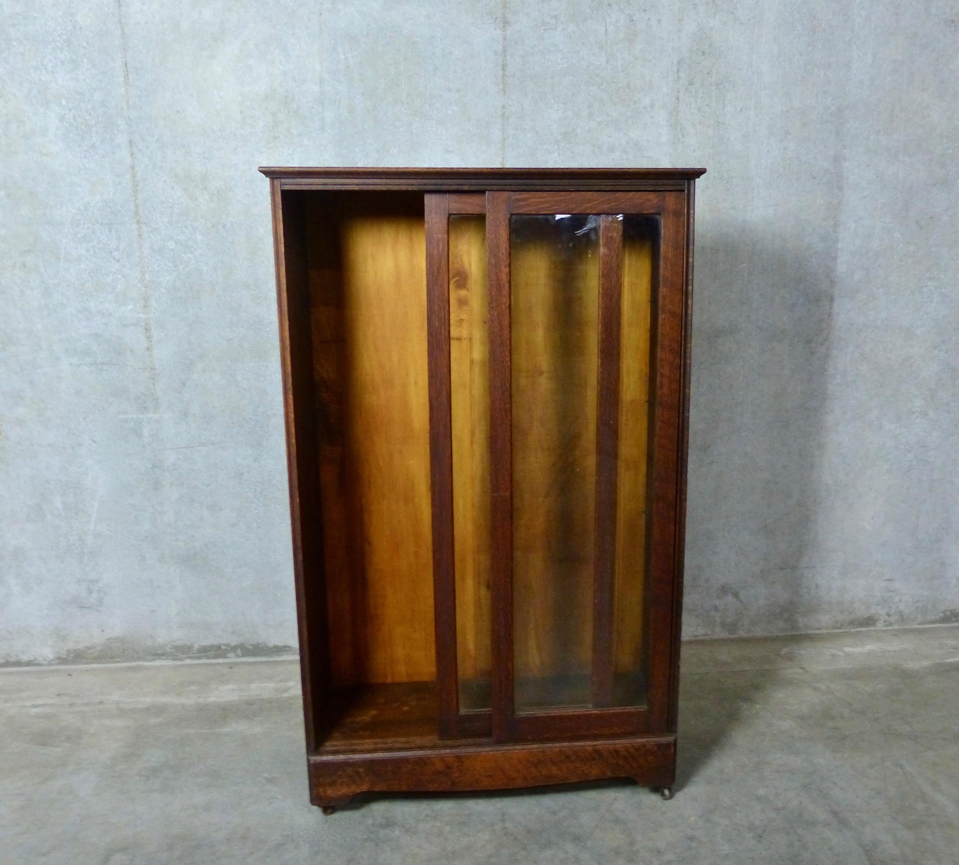 Glass front rolling bookcase or cabinet, circa 1910, in dark oak. Features include a pair of sliding glass doors and three glass interior shelves. Wheels make it a practical, and moveable, display case for your best collectibles.
Dimensions: 54 H”