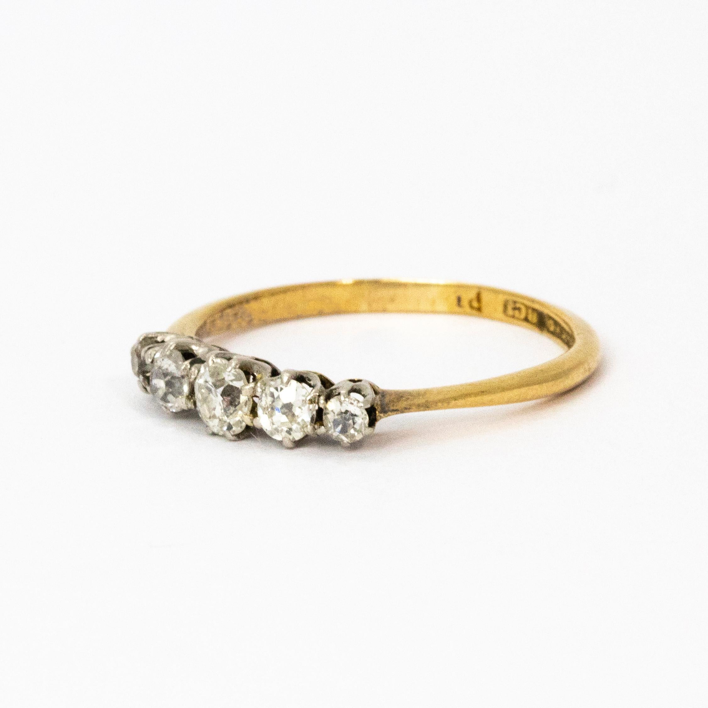 Crafted in 1910, this stunning five-stone ring is set with beautiful white graduated diamonds. The central diamond measures 20 points, the two flanking stones measure 10 points each, and the outside stones measure 5 points each. Total diamond weight