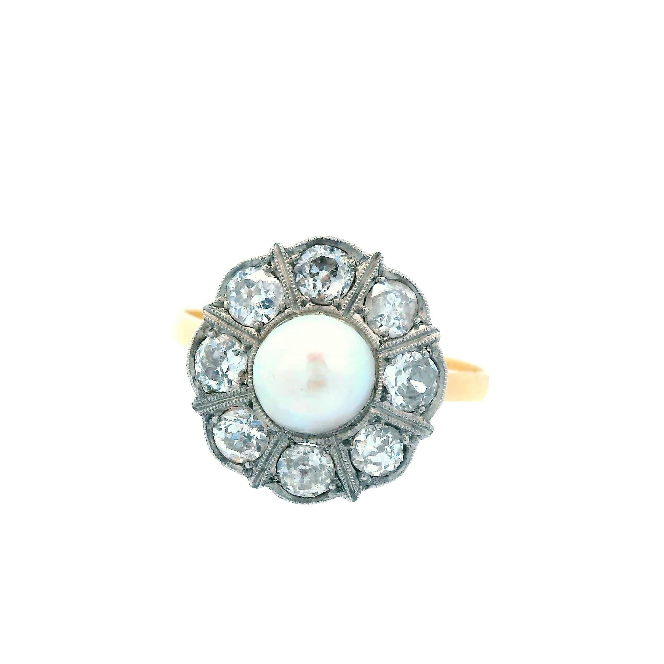 Cette magnifique bague édouardienne à deux tons datant de 1910 est réalisée en or jaune 18 carats sur platine et renferme à la fois un diamant et une perle naturelle. La bague est de taille 6,5 mais peut être redimensionnée sur demande. Le centre de