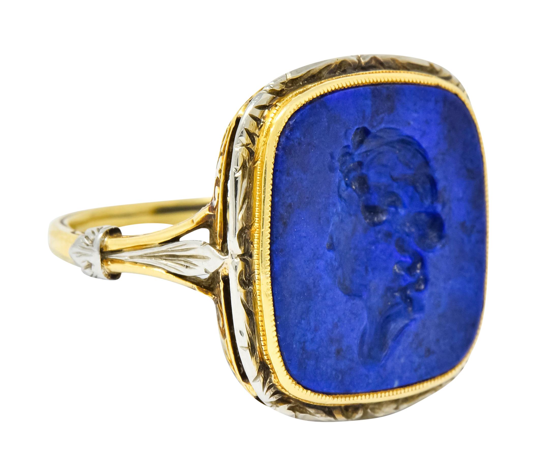 Centering a cushion cut lapis intaglio deeply engraved to depict the profile of a Grecian woman

Lapis is opaque with stunningly even ultramarine color

Bezel set in a milgrain gold surround offset by platinum foliate surround

With ornate foliate