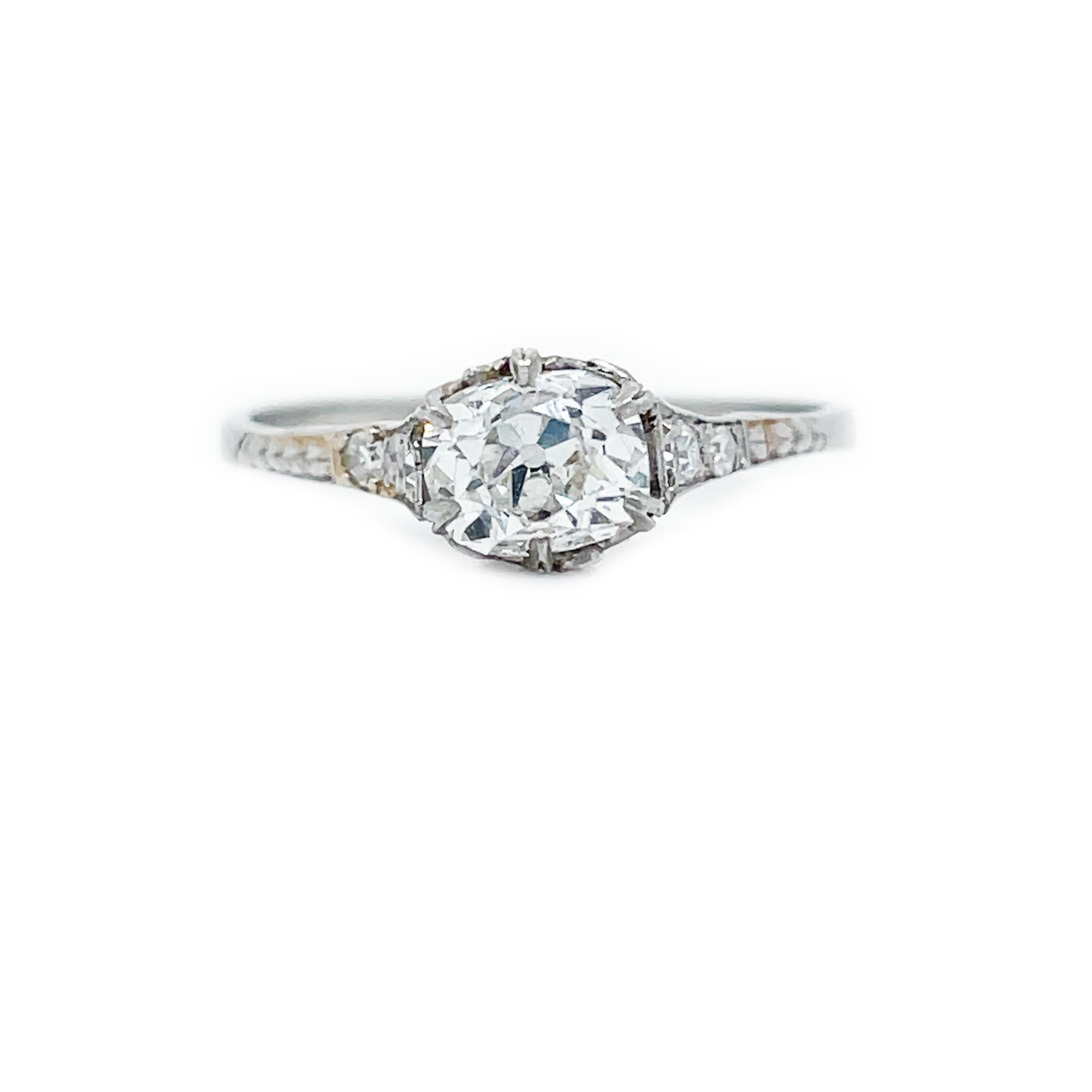 This is a gorgeous Edwardian engagement ring showcasing a dreamy old mine-cut diamond set in Platinum! Crowned by a 0.79 ct icy white old mine cut diamond at its center, this platinum set engagement ring is adorned with glittering diamond set