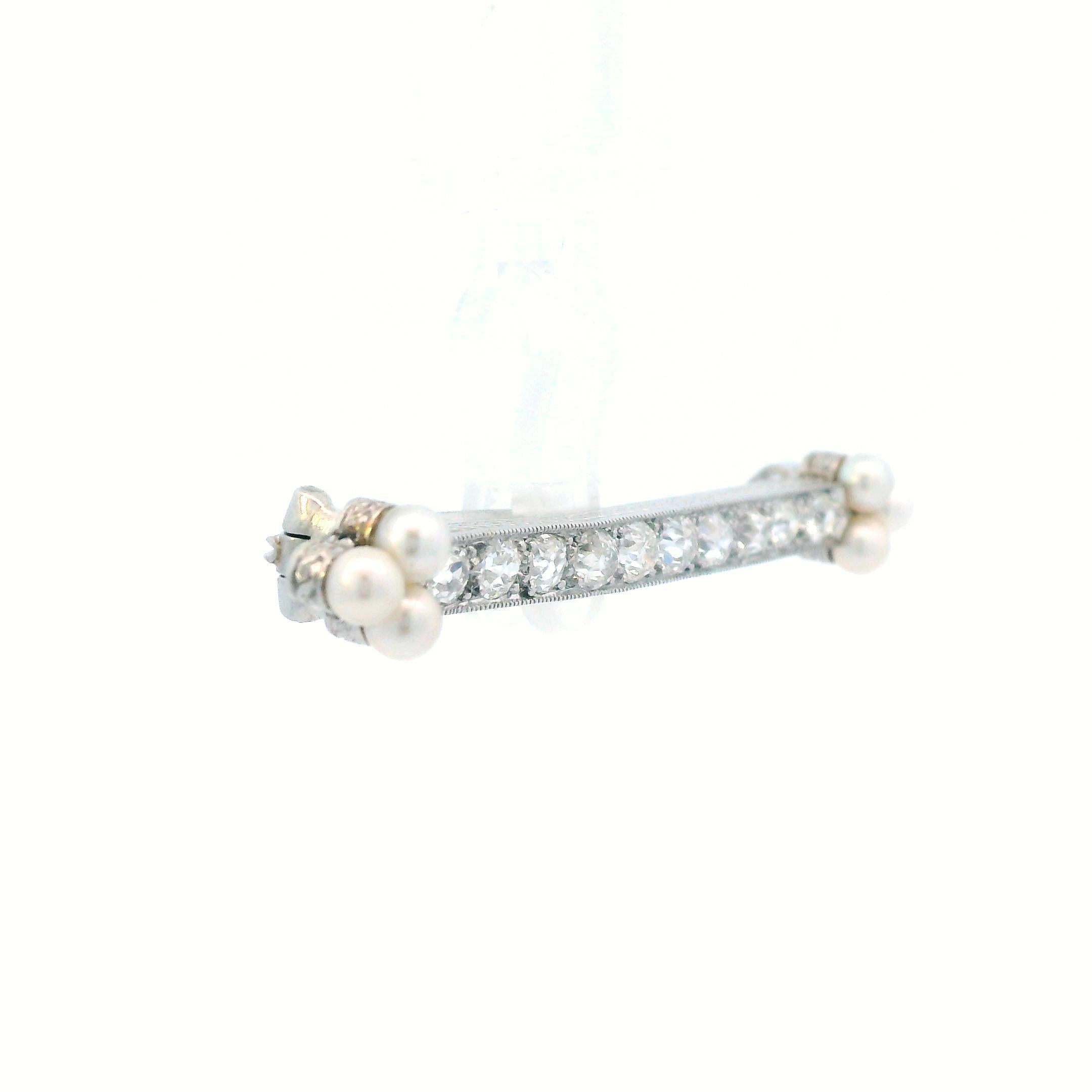 This is a dreamy brooch dating back to the Edwardian period crafted in Platinum that showcases bright white pearls and diamonds! This is a stunning bar pin that is classic and timeless. This lovely pin is adorned with 10 gleaming old mine-cut