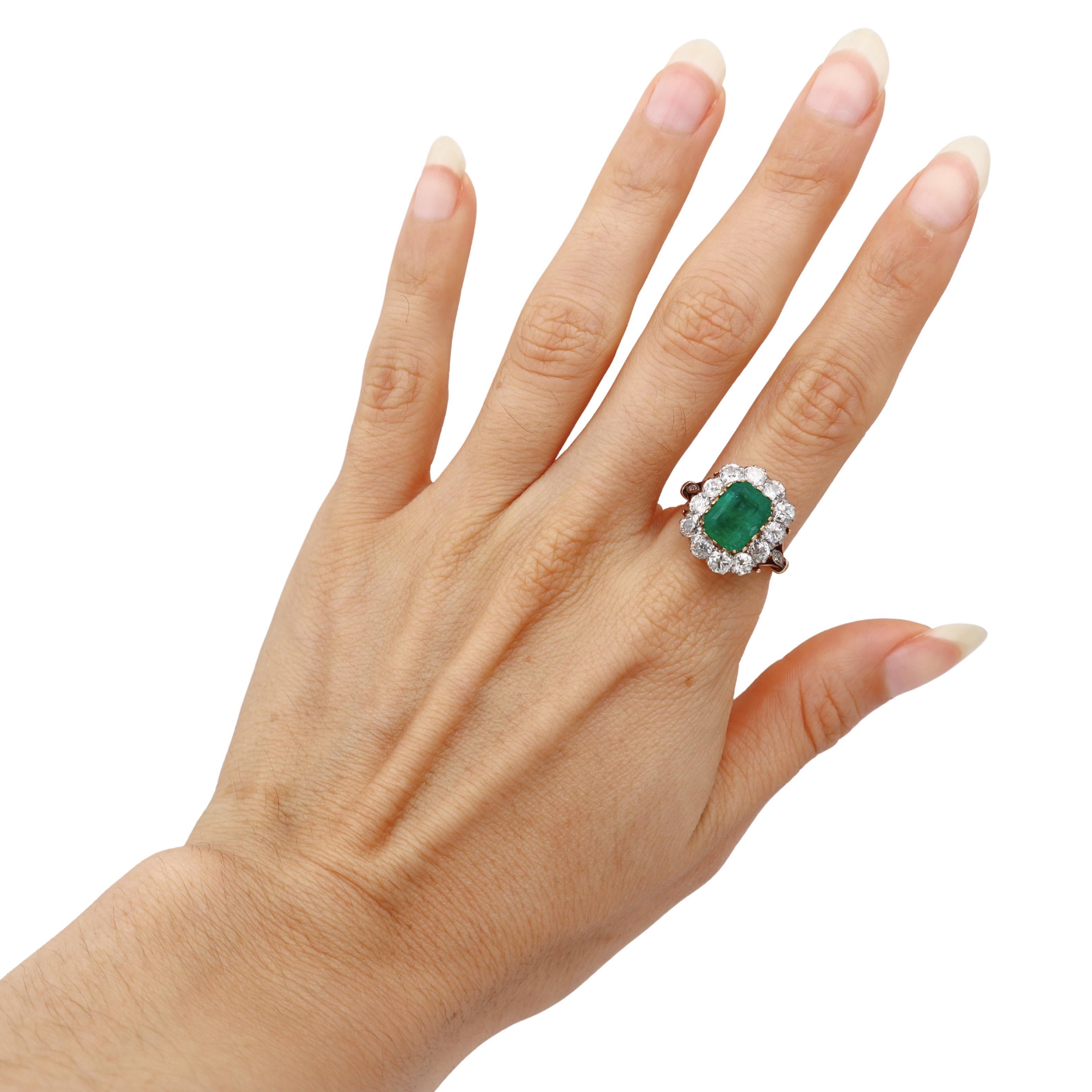 Este magnífico anillo eduardiano de 1900-1910 ejemplifica la refinada elegancia de la época, elaborado en lustroso oro amarillo de 18 quilates y platino, con una impresionante esmeralda talla esmeralda de 2,80 quilates como regia pieza central,