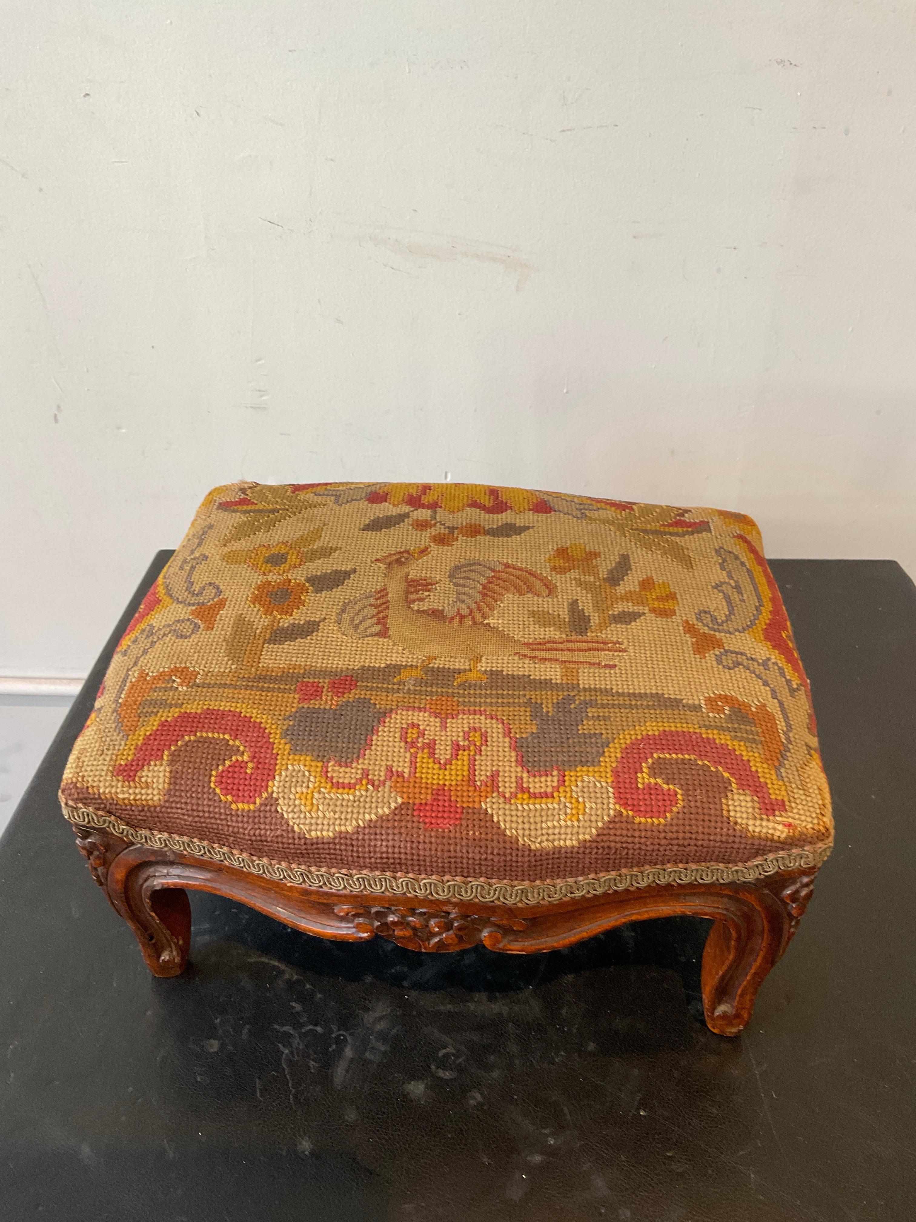 1910 French hand carved wood footstool with needlepoint top. Small tear in fabric as shown in 8th picture.