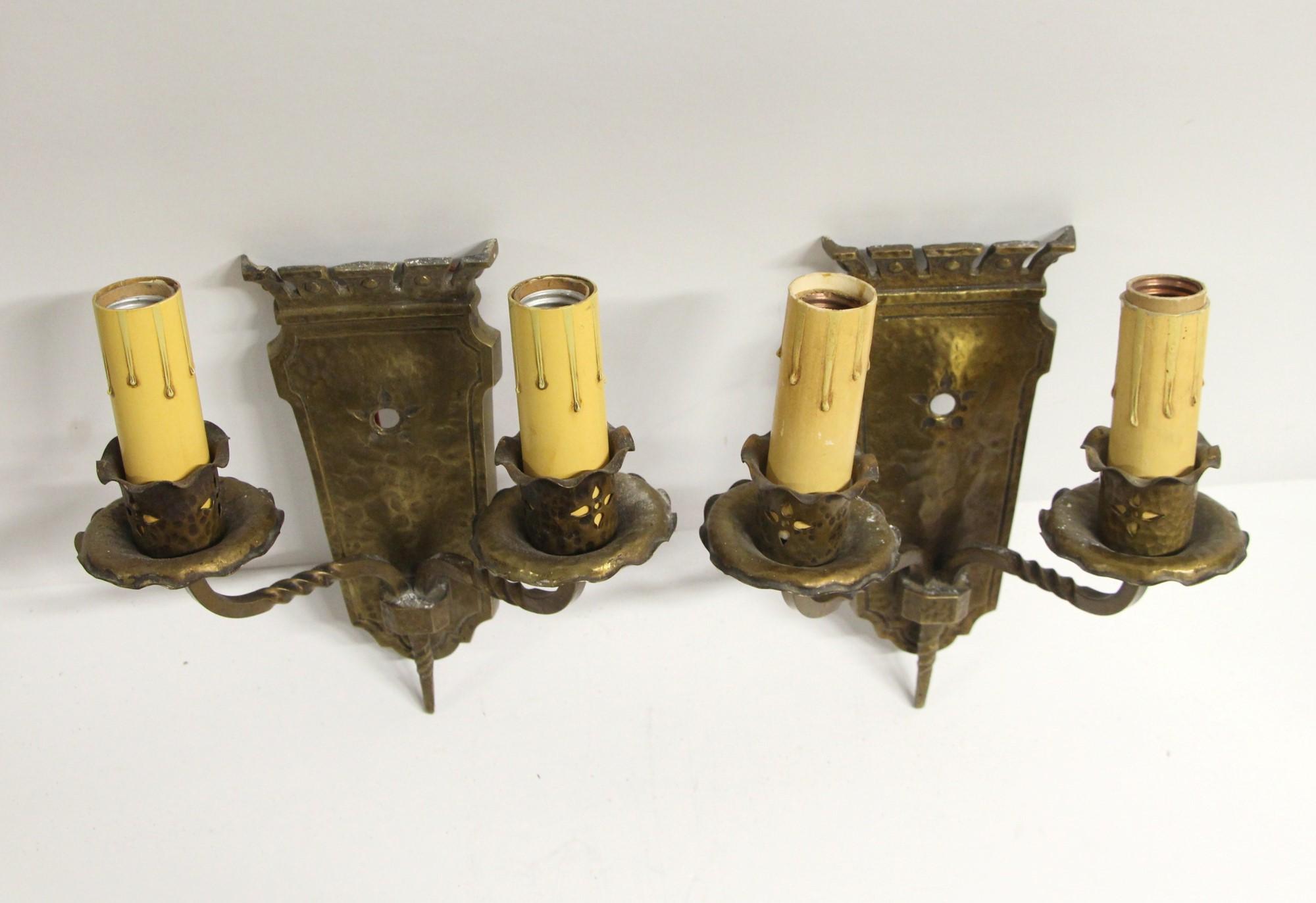 Pair of 1910 Arts & Crafts heavy cast bronze sconces with two lights each and hammered details. Priced as a pair. This can be seen at our 400 Gilligan St location in Scranton, PA.
