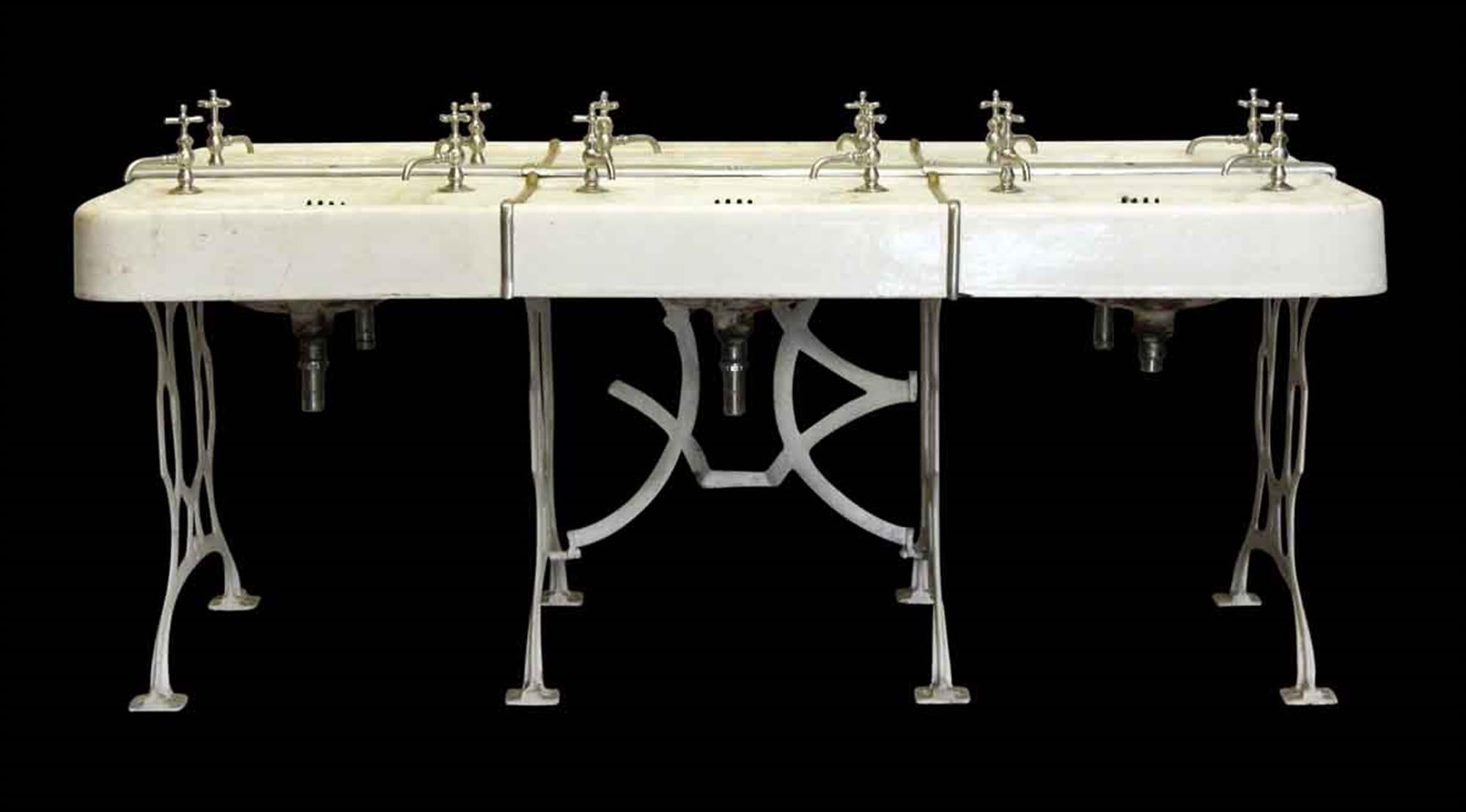 This is an original old 1910 set of bathroom school sinks ganged together with decorative cabriolet white cast iron legs. Some replica hardware is included. This can be seen at our 400 Gilligan St location in Scranton, PA.