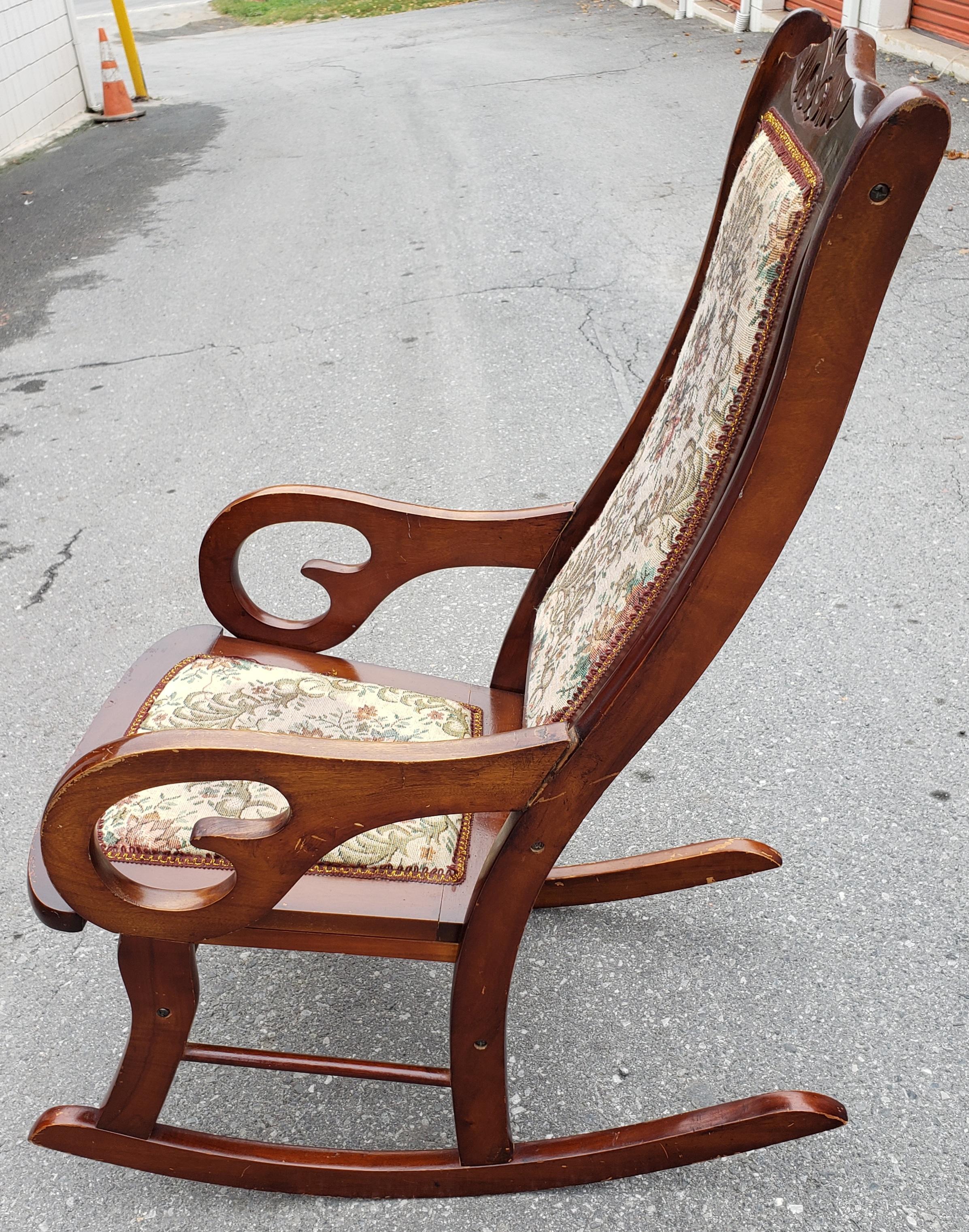 Antique Biedermeier style rocking chair, Mahogany With Needle Point Upholstery Circa 1910s. Good antique condition with some wear and nicks appropriate with age and use. Ams joins to back appear to have been repaired at some point but are in very