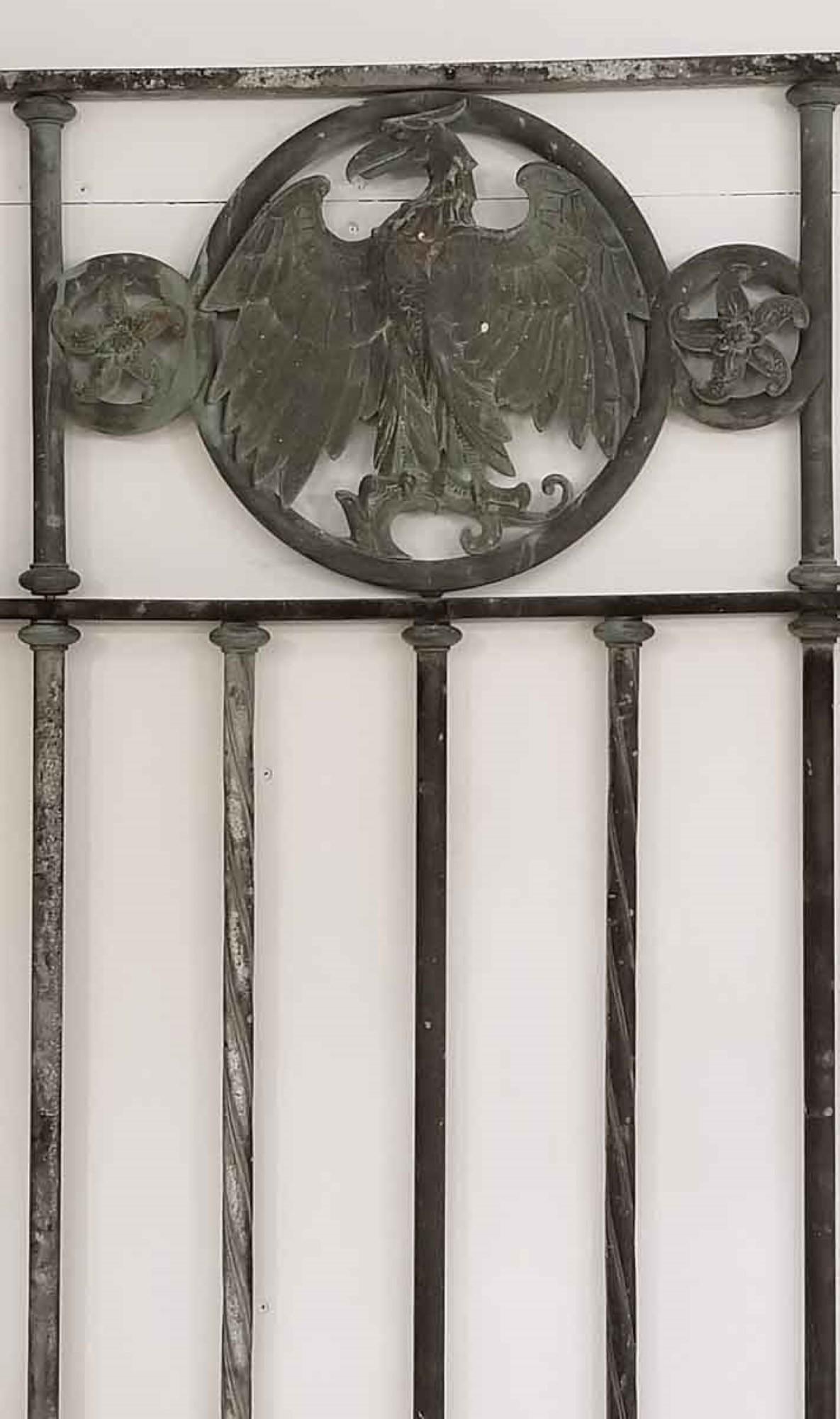 Original 1910s bronze gate panel with seven hand wrought alternating twisted and straight spindles. Features a grotesque eagle medallion on top. Items of this quality and likeness usually came from banks, and this was probably some type of window
