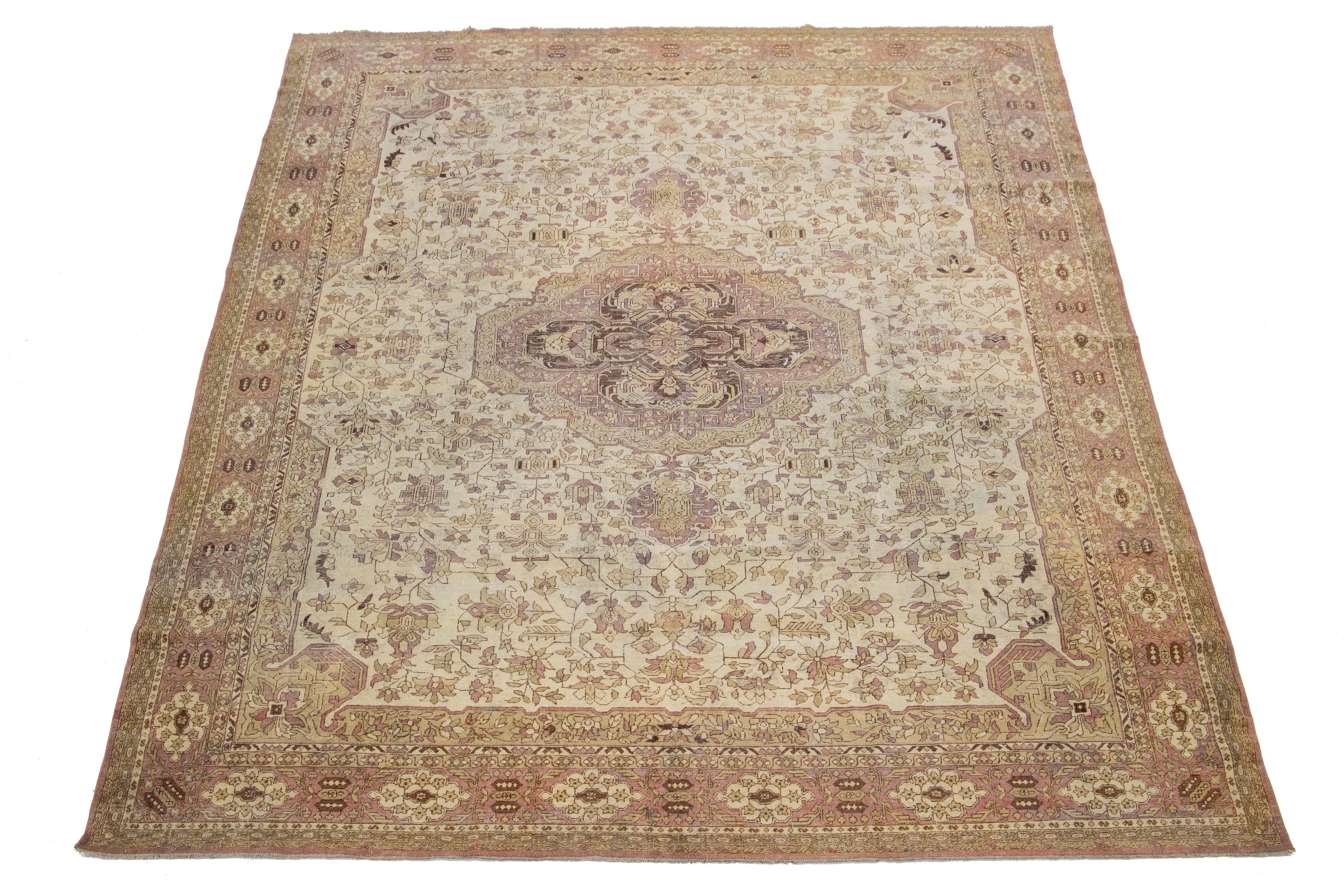 Dieser exquisite, handgeknüpfte Teppich aus Agra-Wolle zeichnet sich durch ein beigefarbenes Feld aus, das von braunen und terrakottafarbenen Motiven in einem zeitlosen floralen Medaillonmuster akzentuiert wird.

Dieser Teppich misst 8'7