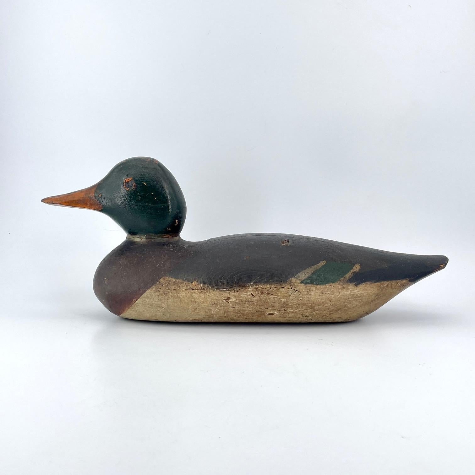 A very old Mallard Drake decoy with original paint; green head, and faded black body. Minor gunning wear, and split to bottom of body.
 