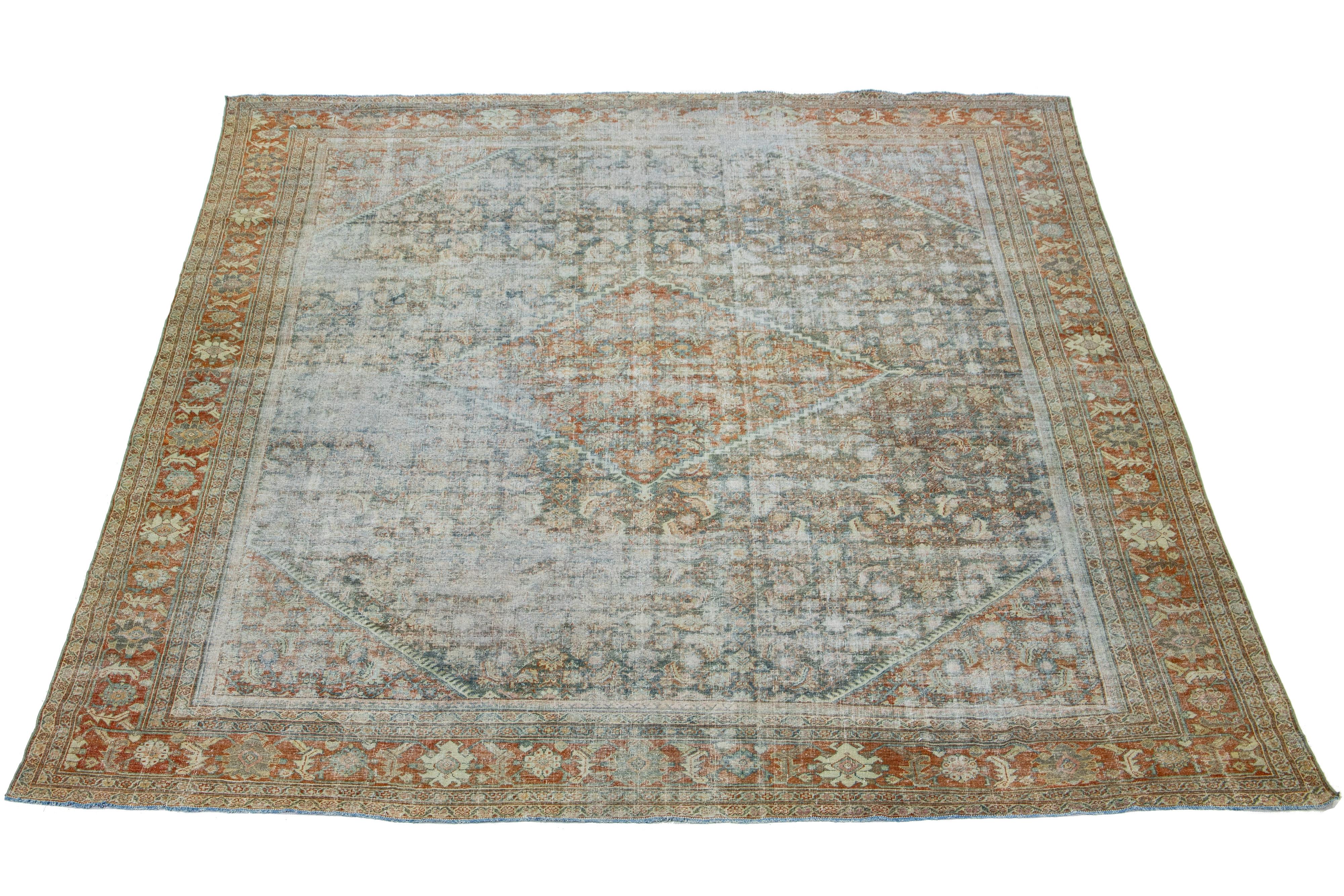 Beautiful Antique Mahal hand-knotted wool rug with a rust color field. This Persian rug has classic blue, gray, beige, and brown hues throughout the floral motif.

This rug measures 12'3