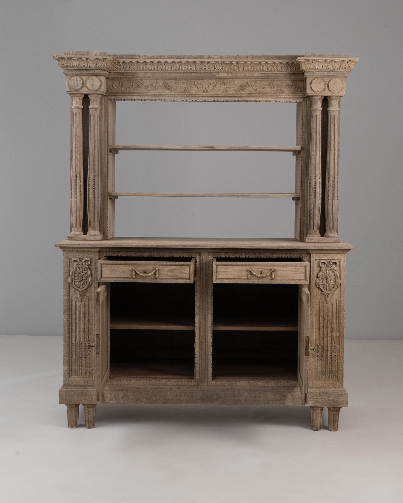 1910s Renacimiento Belga Armario De Roble Con Columnas Talladas. Este impresionante armario está ricamente detallado, mostrando la grandeza y la influencia arquitectónica características del estilo renacentista. Realizada en roble con una pátina de