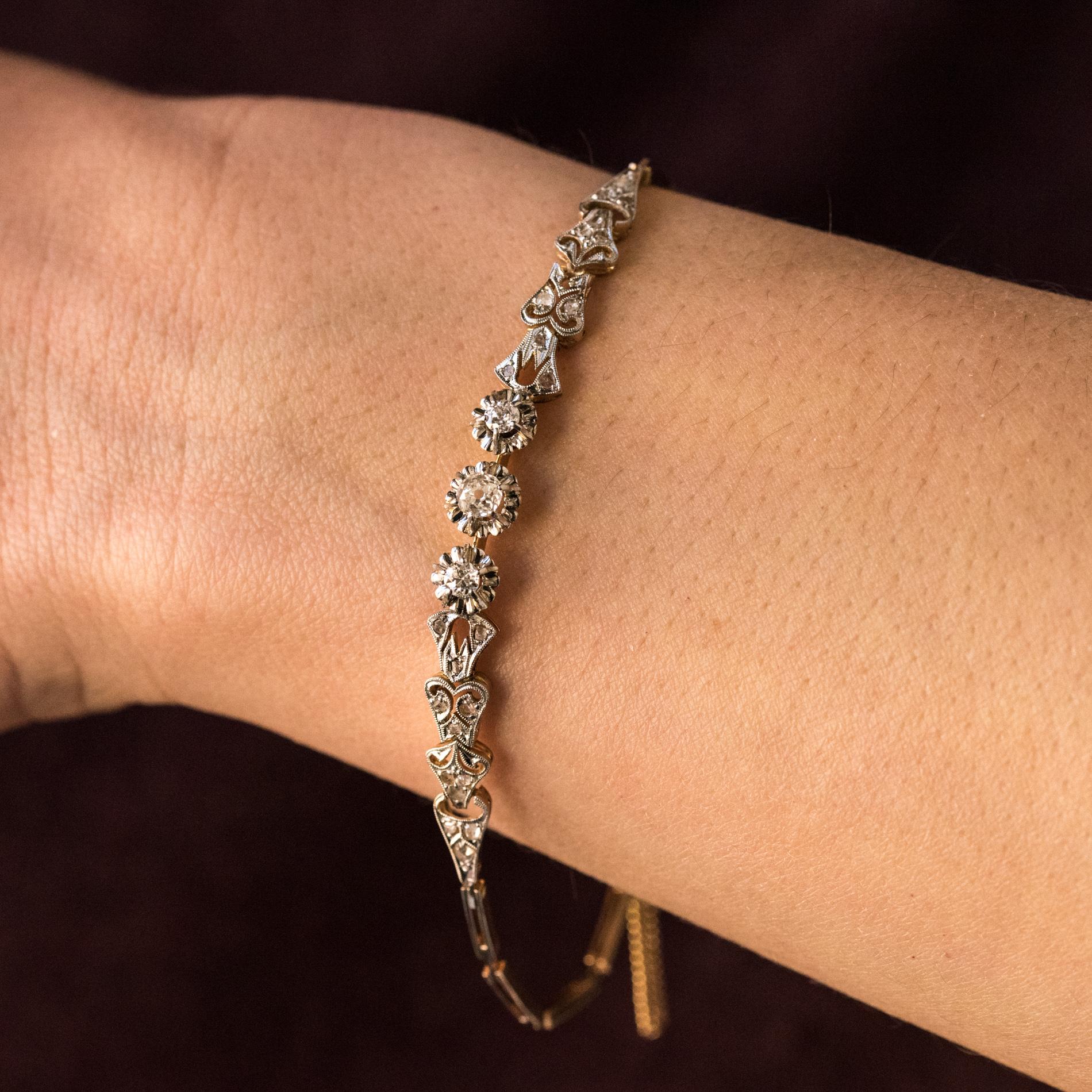 Bracelet in 18 karats yellow gold and platinum.
Delicate antique bracelet, it consists of a gold blade that holds 3 antique-cut diamonds set with claws. They are shouldered on both sides by 4 articulated pattern, openworked, chiseled and set with