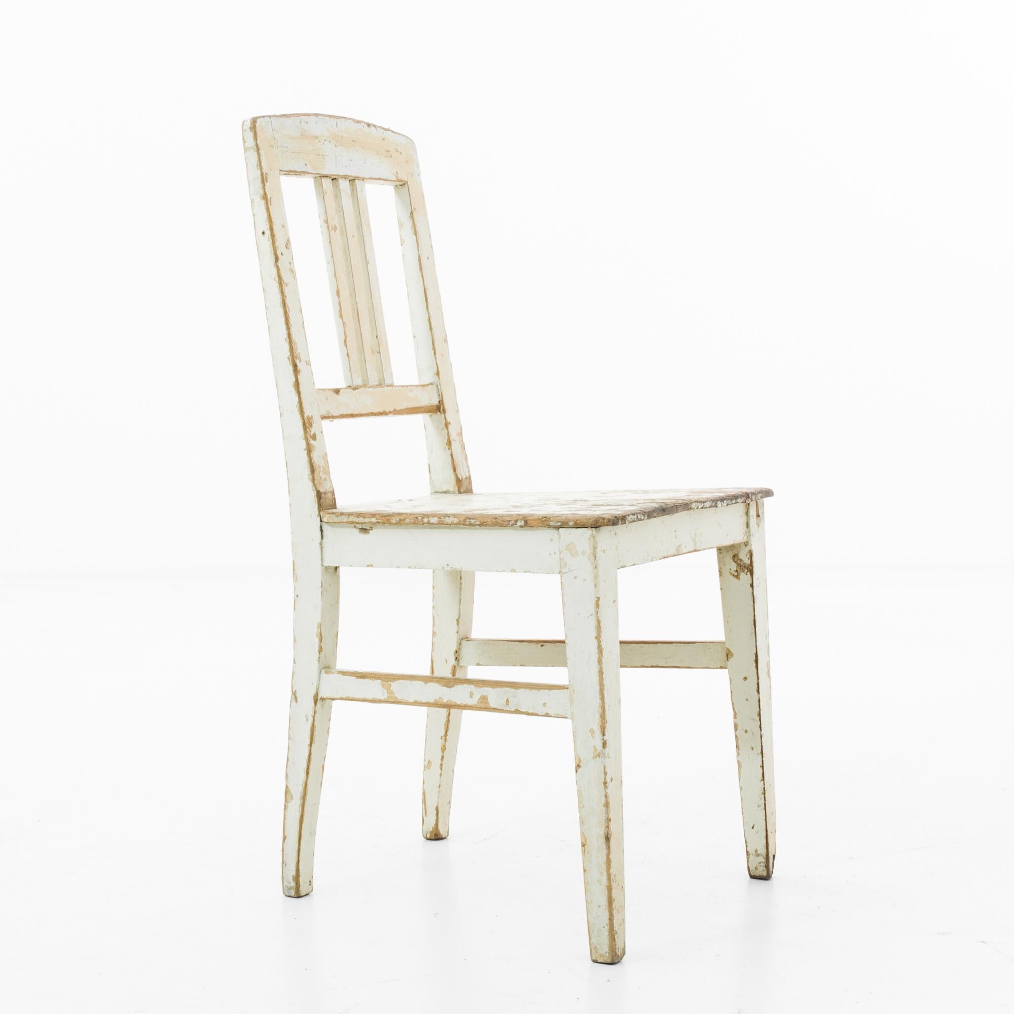 Embrace the authentic vintage charm with this 1910s Czech Wood Patinated Chair. Bearing the beautiful marks of time, its weathered white patina tells a story of a century. Simple yet sturdy, this chair brings a touch of rustic elegance to any space.