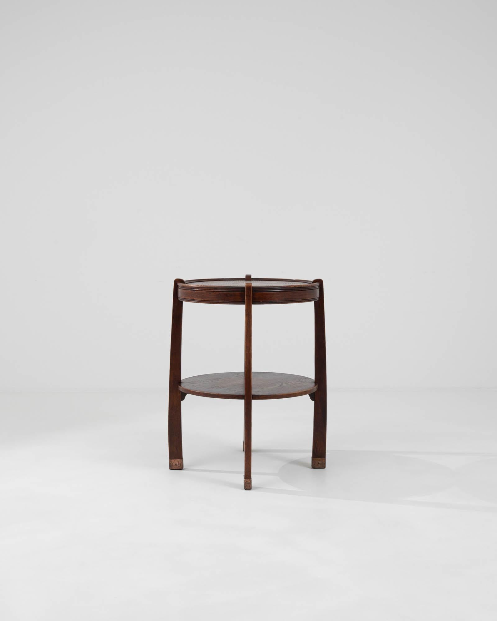 Discover the charm and sophistication of the early 20th century with this 1910s Czech wooden side table. This beautifully preserved piece features a rich, dark wood construction that exudes a timeless elegance. Its round top is intricately inlaid