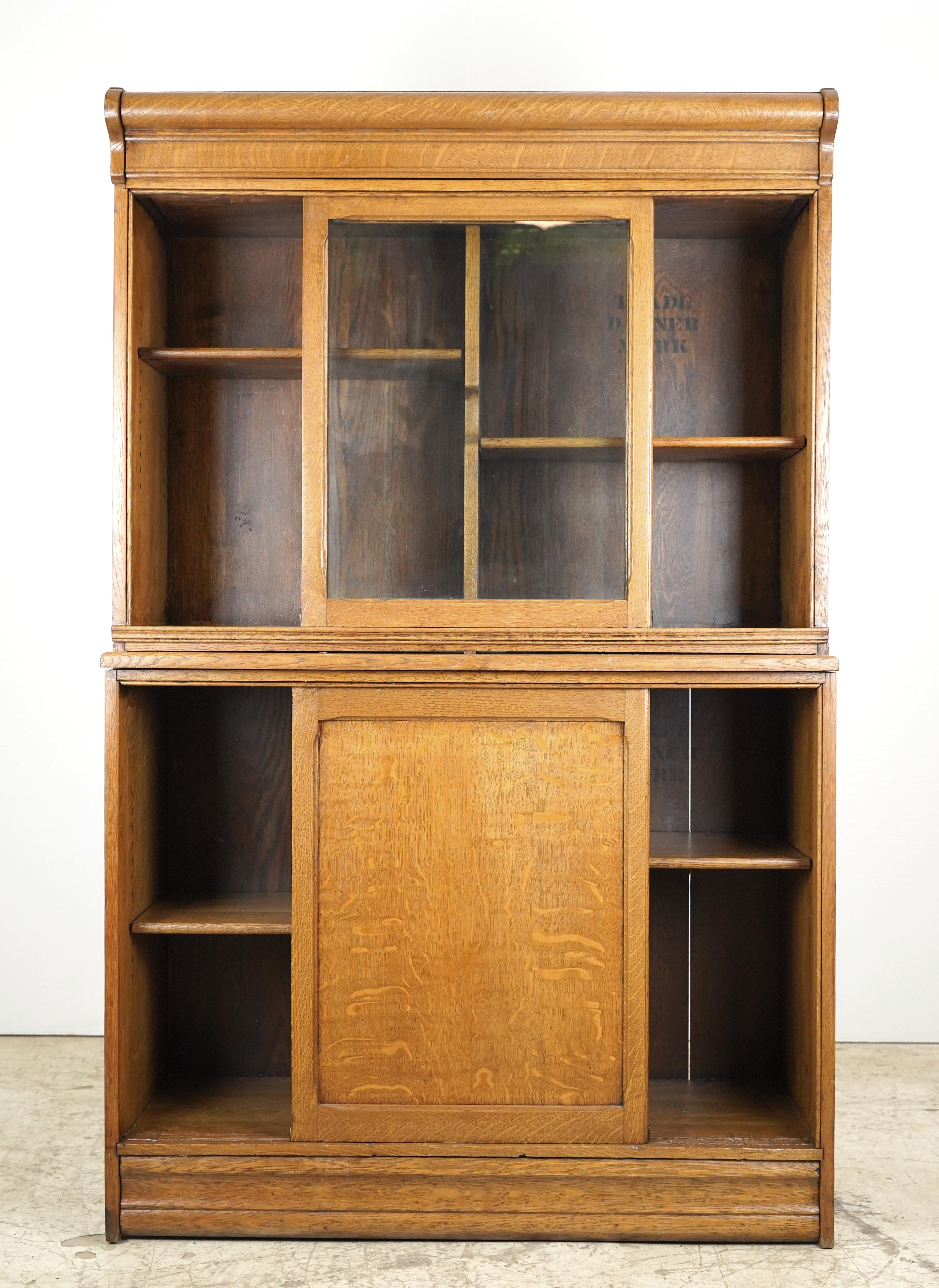 Antica libreria o mobile in rovere tigrato di Danner Furniture del 1910 con due ripiani superiori chiusi da ante in vetro, due ripiani inferiori chiusi da ante scorrevoli in legno massiccio e un piano estraibile a tutta larghezza. Sul retro sono