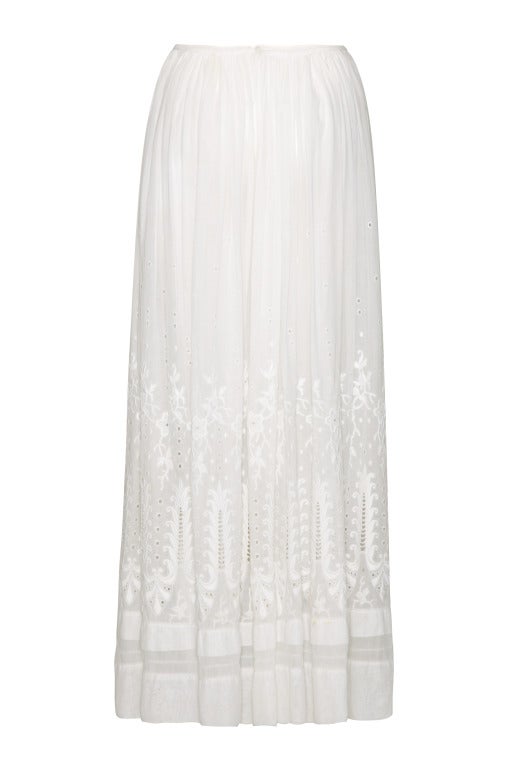 Beautiful sheer white cotton full length Edwardian skirt circa 1910.  This piece is extremely decorative and features large satin stitch embroidery and eyelet work all over.  The skirt is gathered into a waistband, which fastens with a button, and