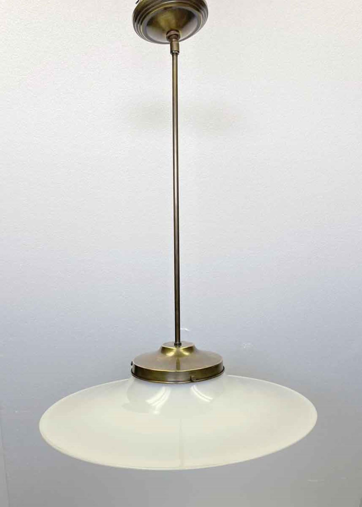 Original 1910s rare flat brim shaped white milk glass shade pictured with a newly configured and wired antique brass finished pole fixture. Forward looking design similar to the Mid-Century Modern styling that started to appear in the 1950s. Price